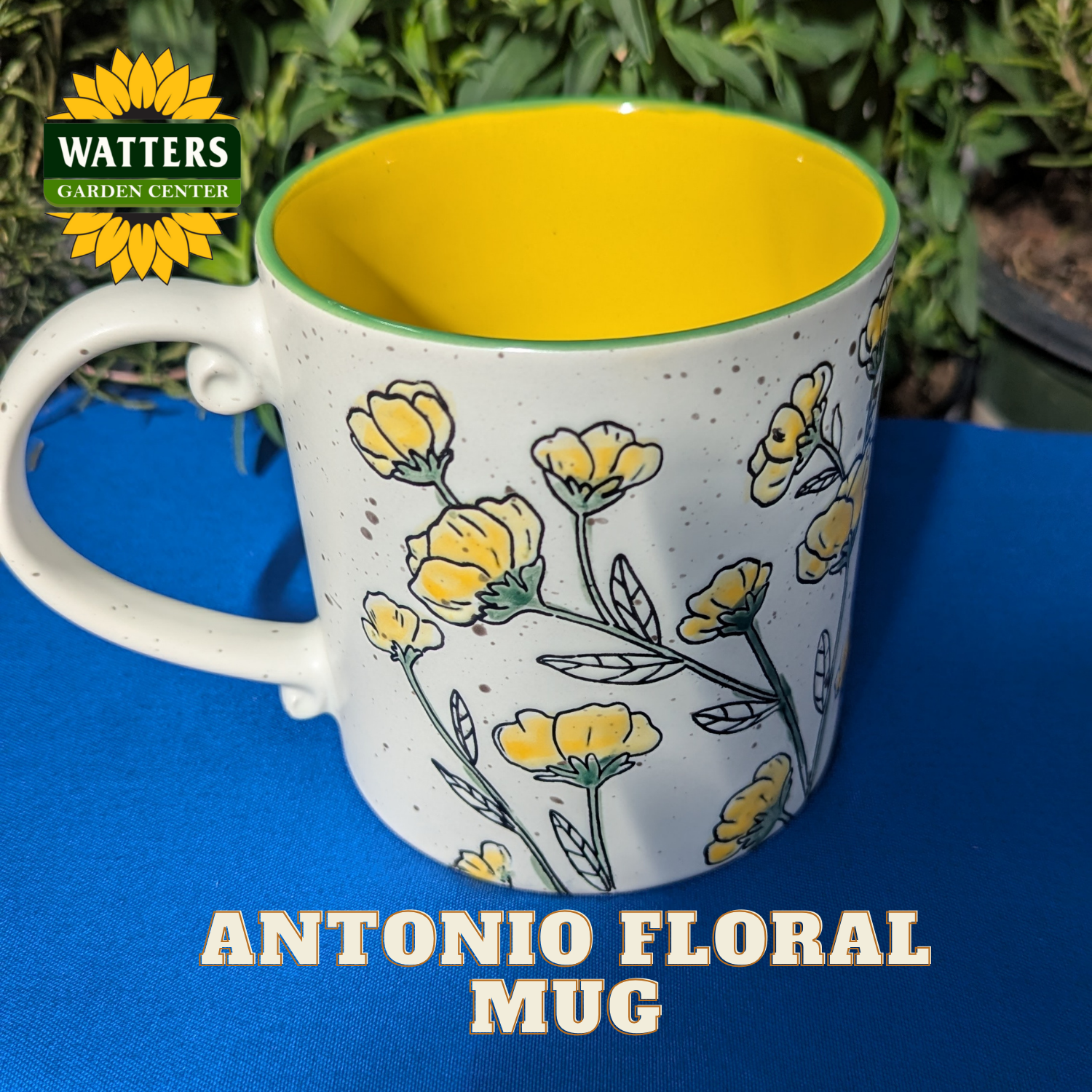 White mug with yellow interior, floral design, and 'Watters Garden Center' logo.