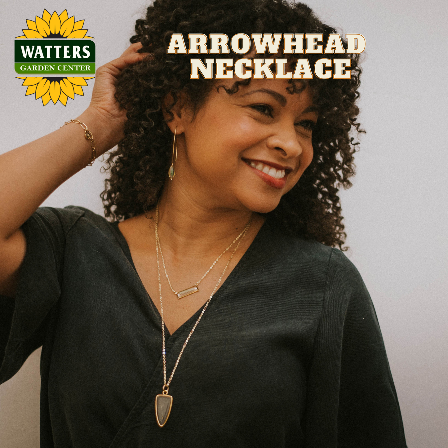 Woman wearing an arrowhead necklace with Watters Garden Center logo.