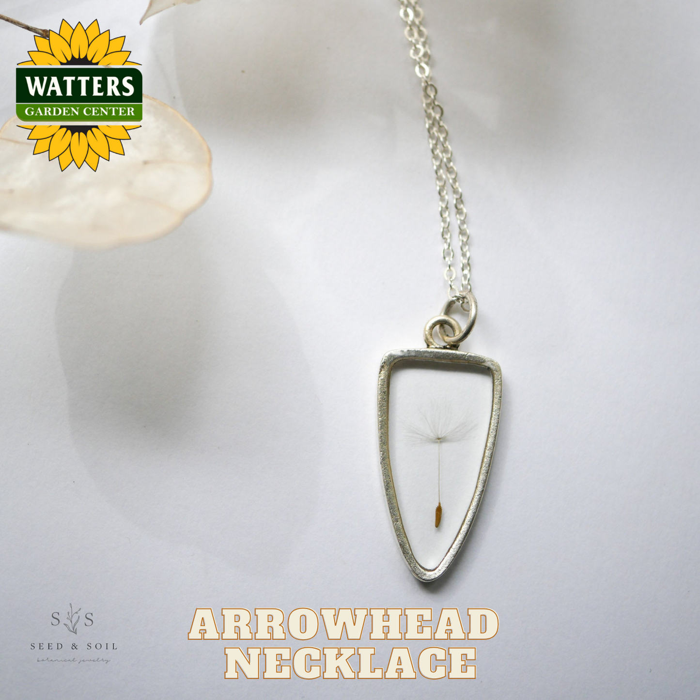 Arrowhead necklace with a white stone pendant on a light background, featuring Watters Garden Center logo.