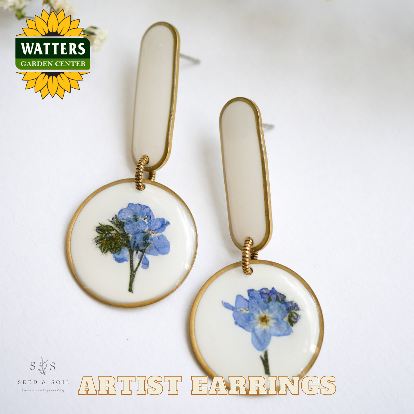 Pair of earrings with floral design on a white background, featuring Watters Garden Center logo.