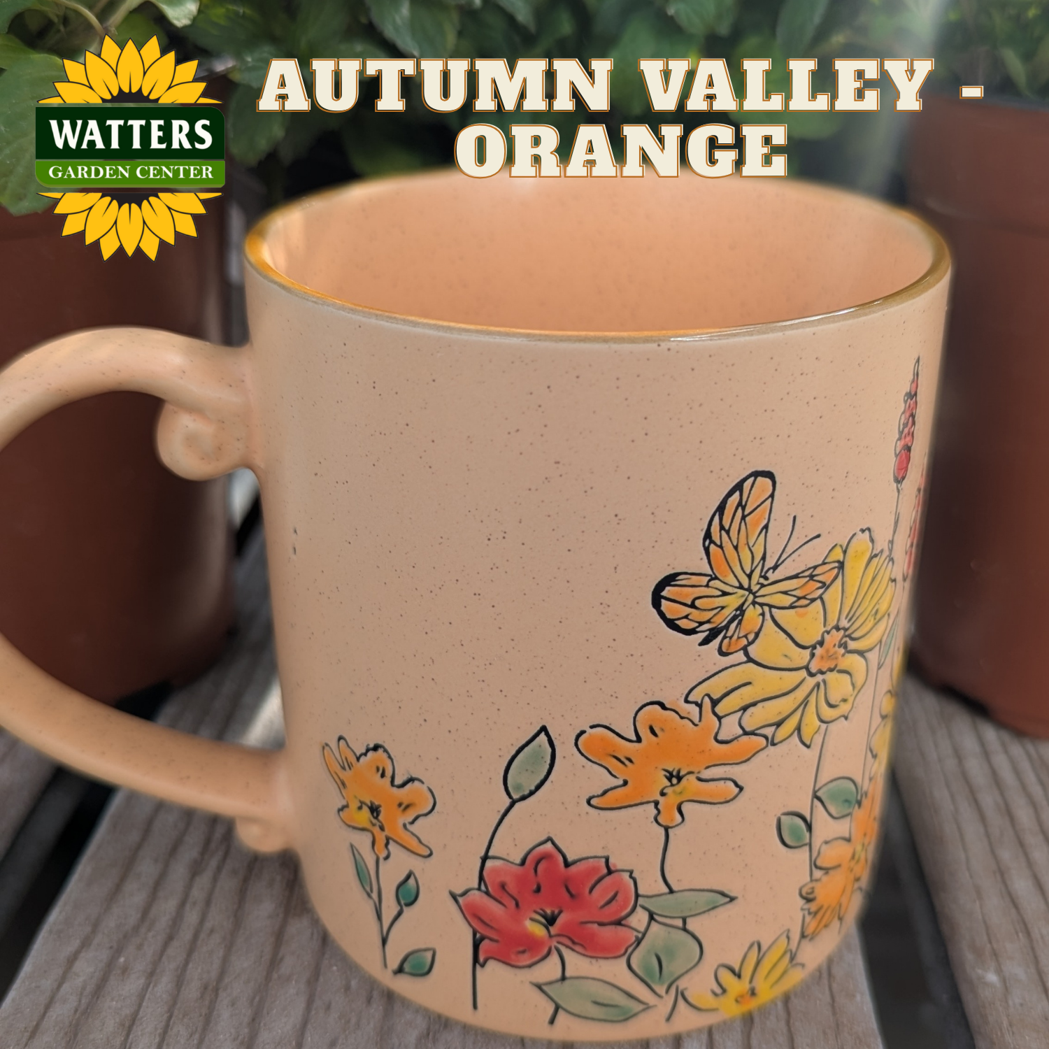 Mug with floral designs on a wooden surface, featuring Watters Garden Center branding.