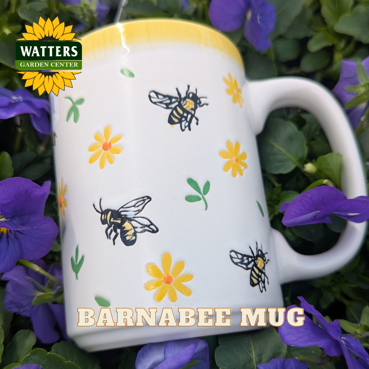 White mug with bee and flower design, surrounded by purple flowers, with Watters Garden Center logo.