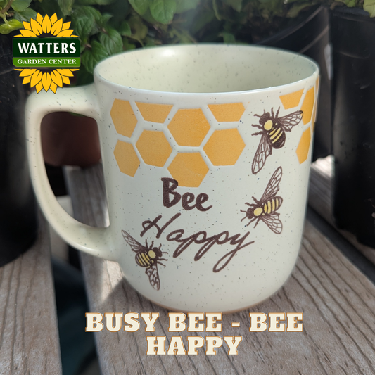Mug with bee design and 'Bee Happy' text on a wooden surface, featuring Watters Garden Center logo.