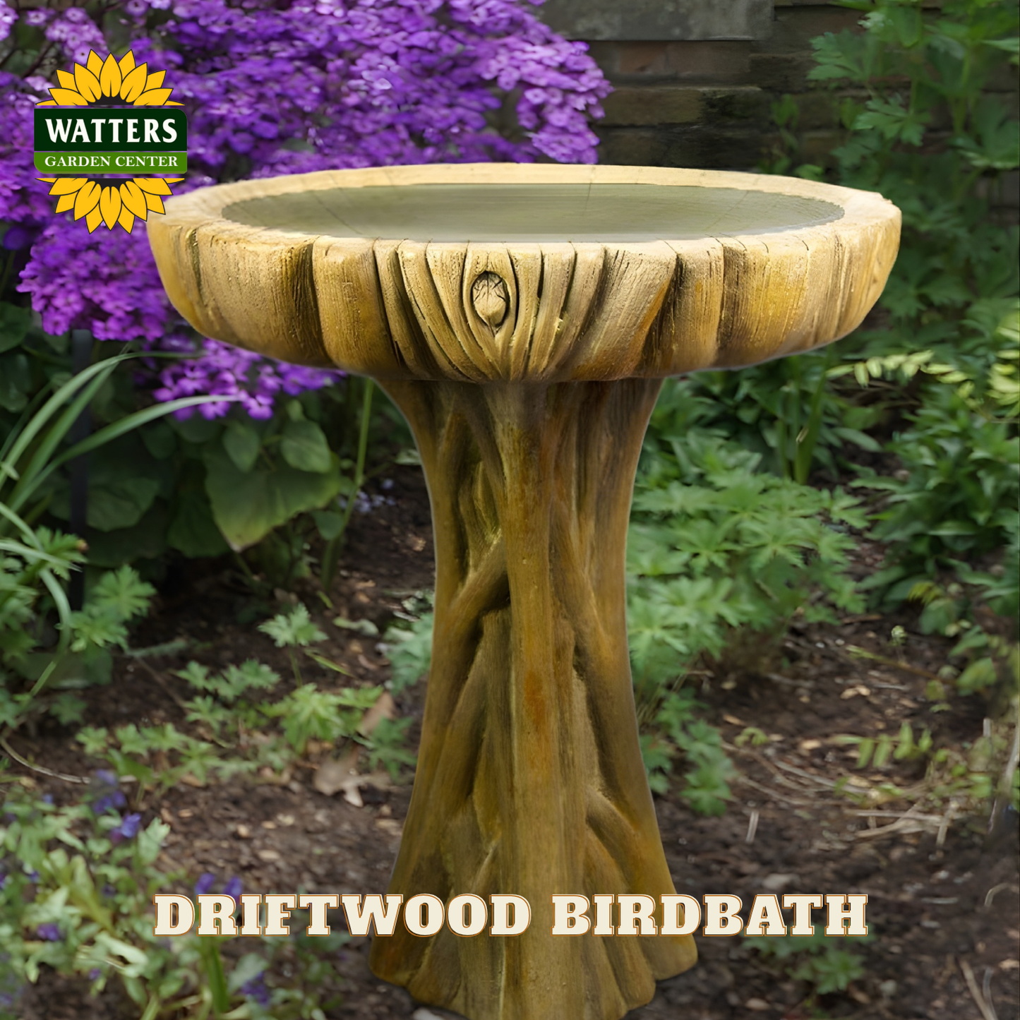 Driftwood-style birdbath with Watters Garden Center logo in a garden setting.