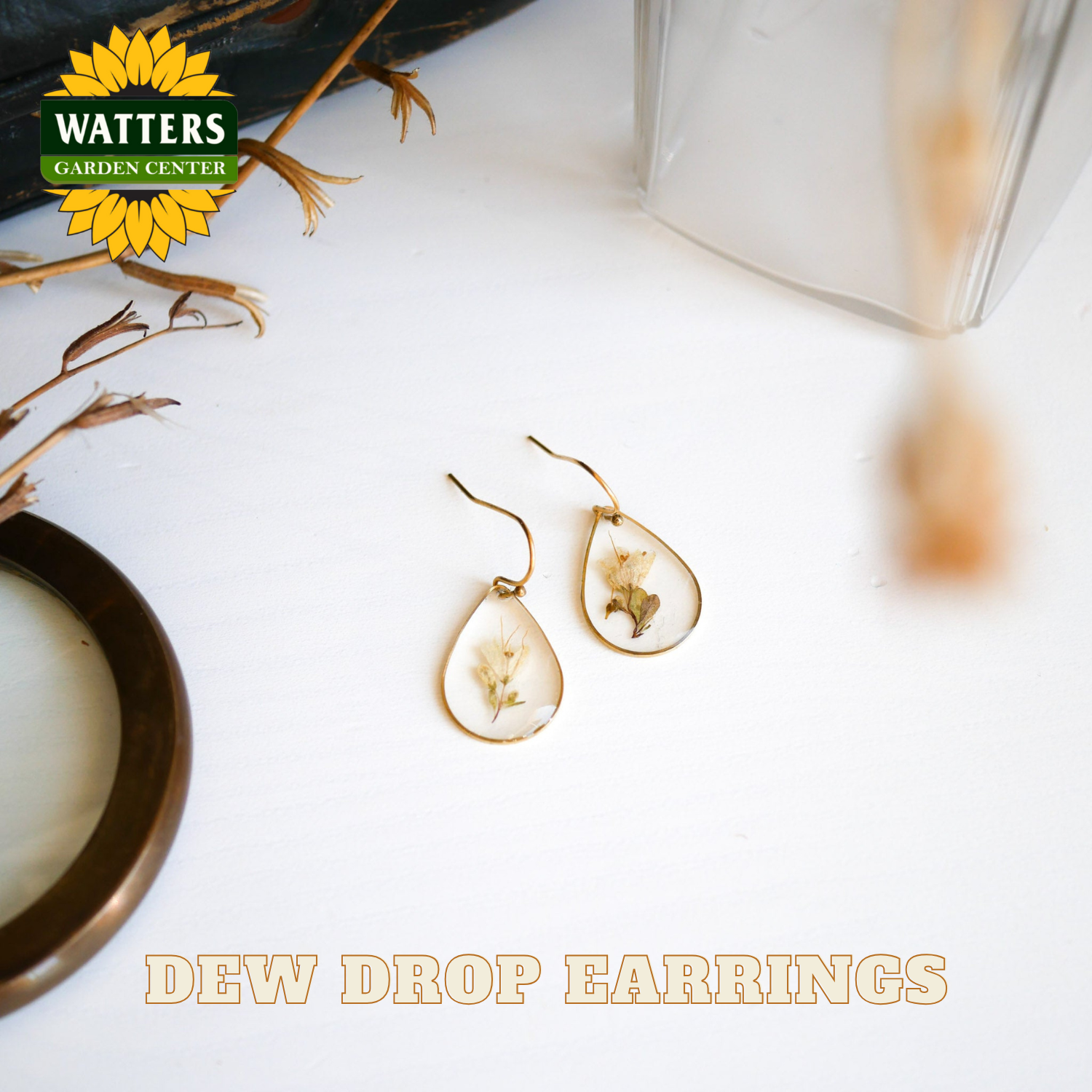 Dew drop earrings on a white surface with Watters Garden Center branding.