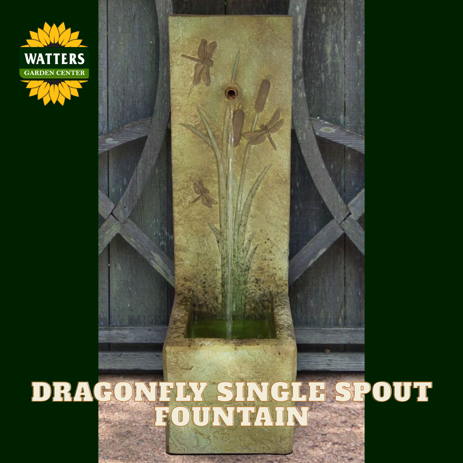 A Watters Garden Center dragonfly single spout fountain shown outdoors against a weathered wooden gate. The tall rectangular stone fountain has embossed dragonfly and cattail designs on a textured tan surface, with water flowing into a shallow basin below.