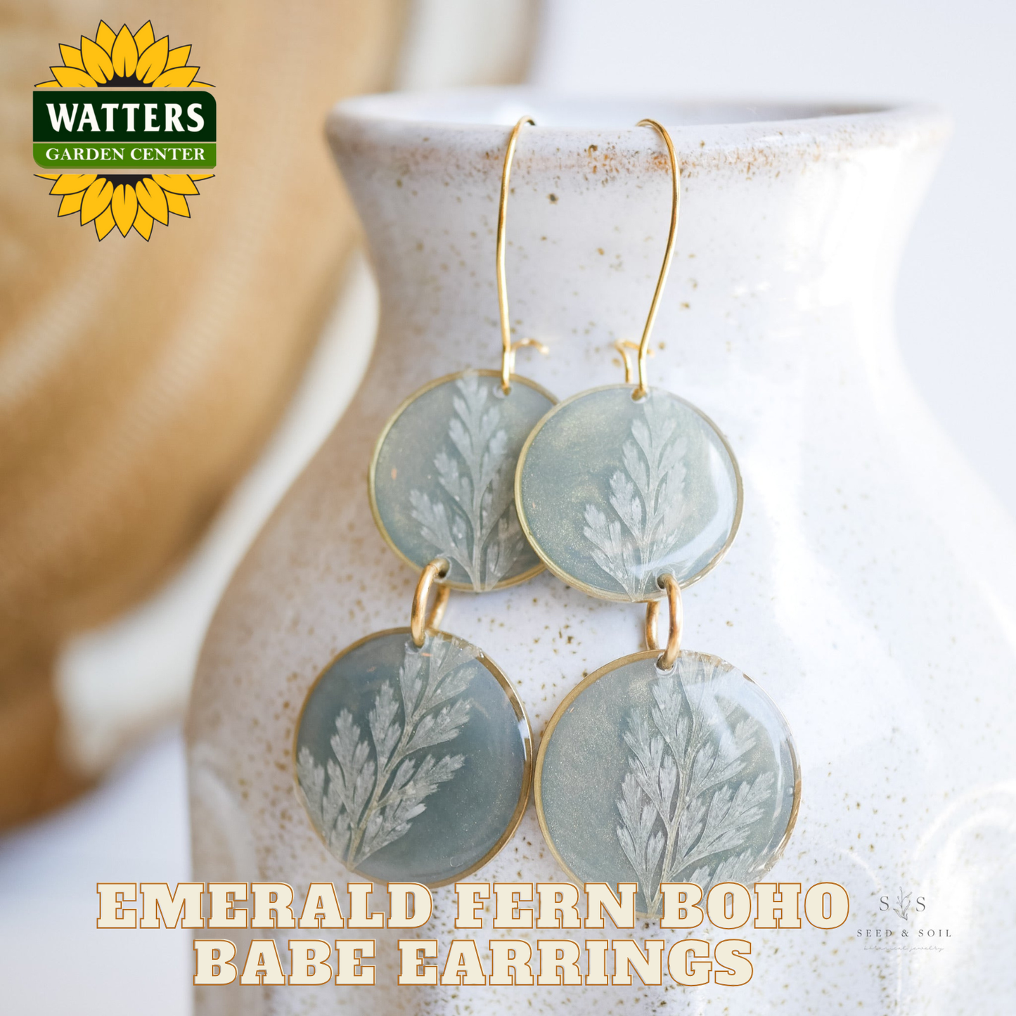 Emerald fern boho babe earrings on a white vase with Watters Garden Center logo.