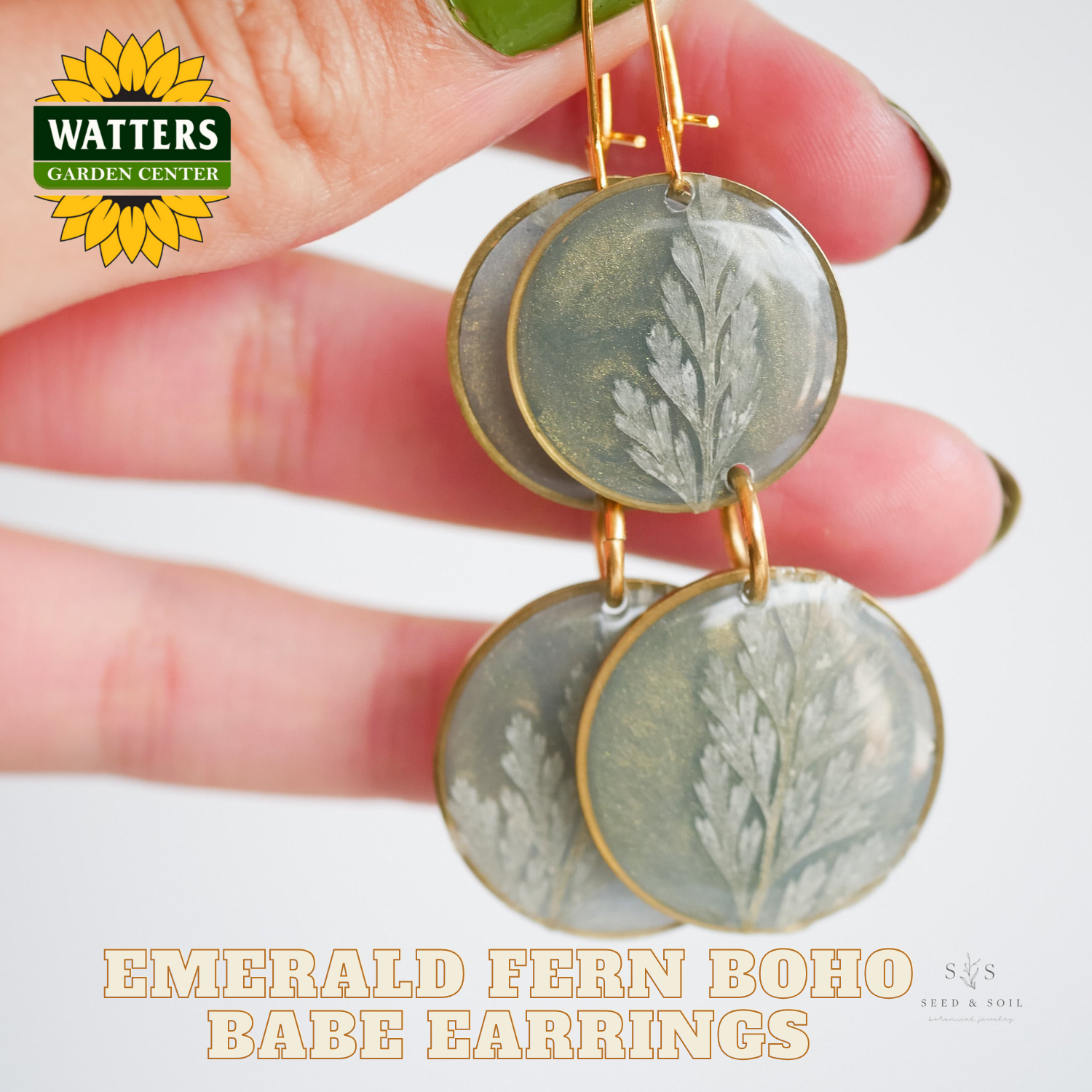 Earrings with green circular designs held by a hand, Watters Garden Center logo visible.