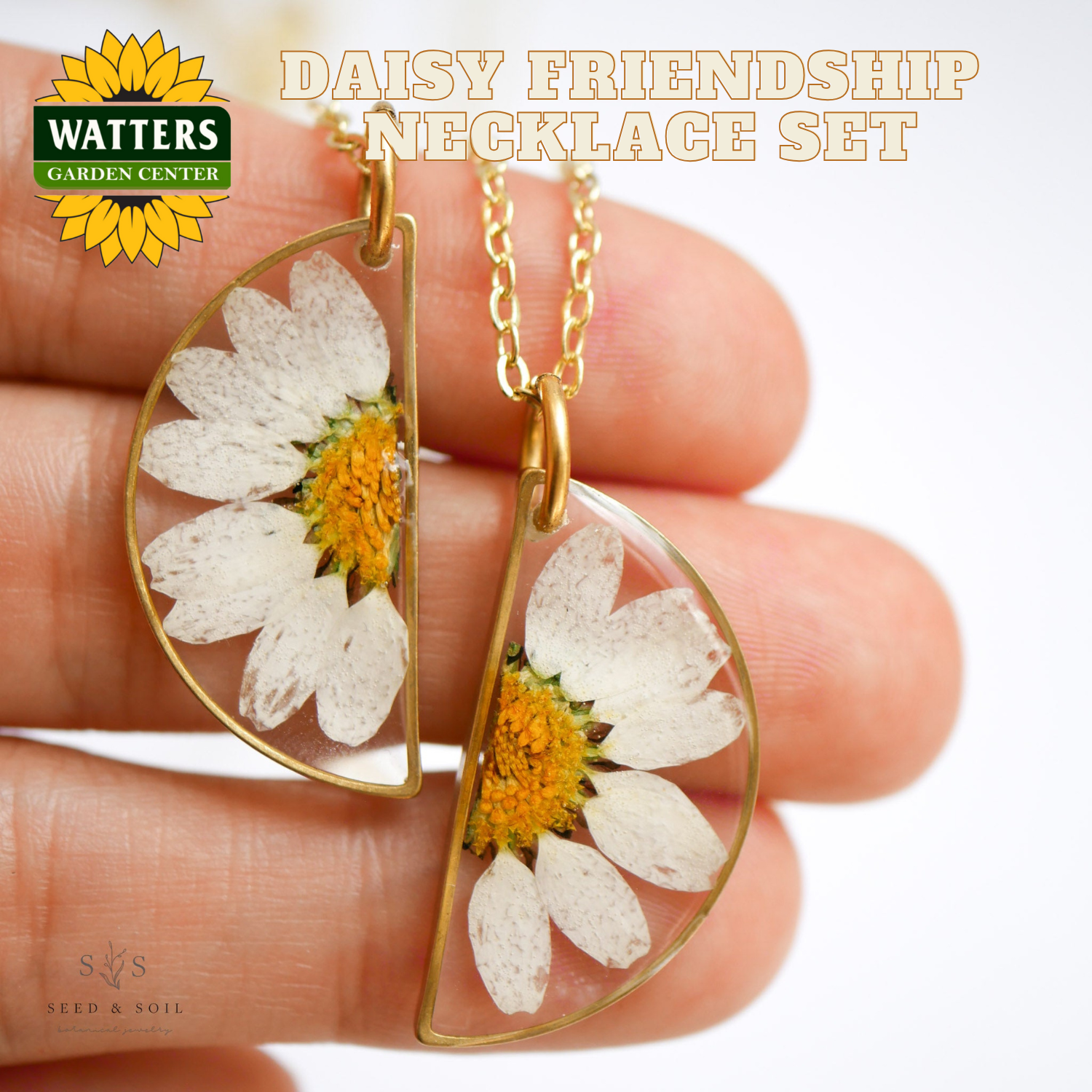 Daisy friendship necklace set held between fingers with Watters Garden Center logo.