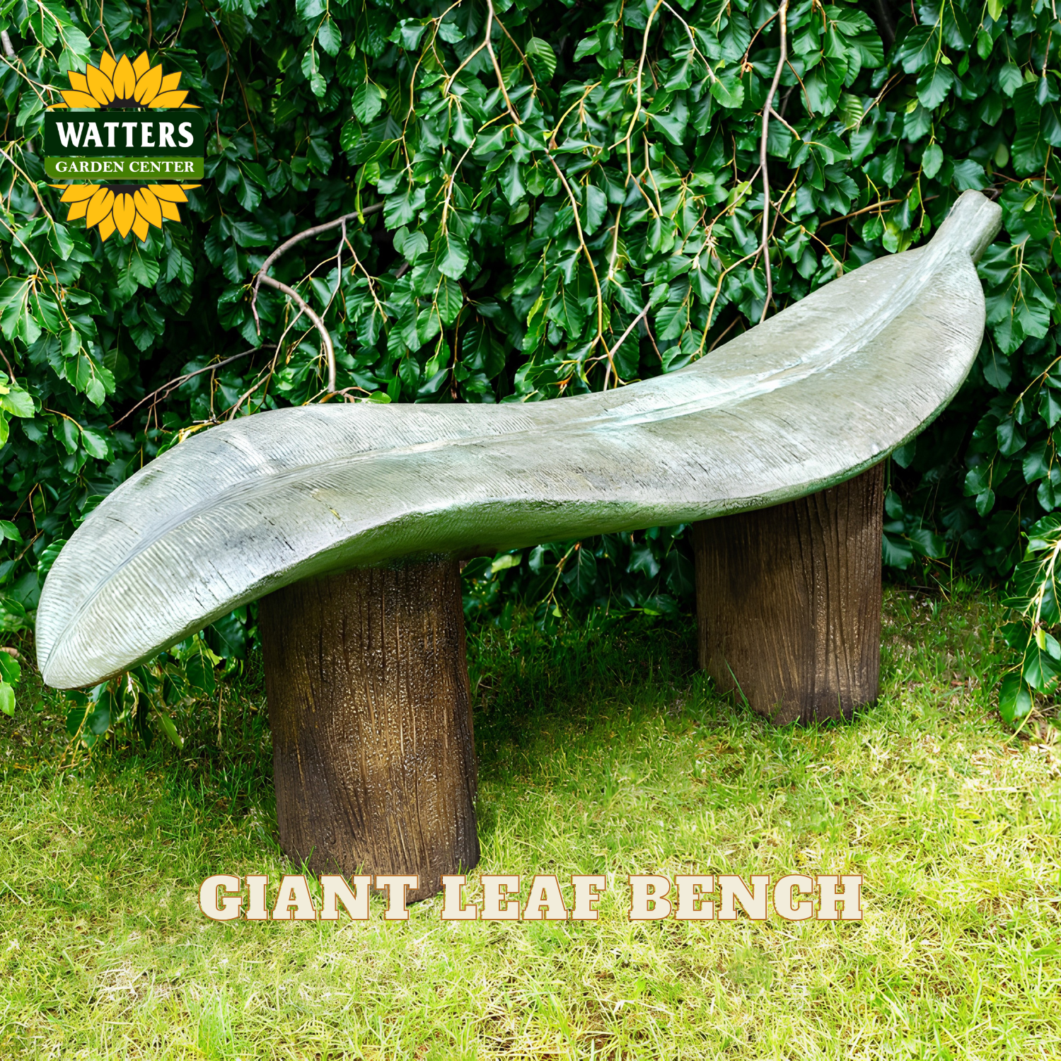A leaf-shaped outdoor bench made of weathered gray stone or concrete, mounted on two dark brown cylindrical posts, set in a garden with green grass and a leafy hedge background. Text overlays read 'GIANT LEAF BENCH' and a 'WATTERS GARDENS CENTER' logo is visible in the top left.