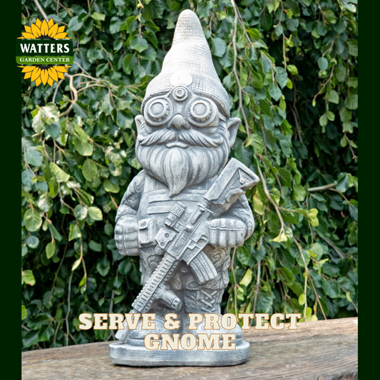 A gray stone-look garden gnome statue holding a rifle, displayed outdoors on a wooden surface with green foliage in the background. A Watters Gardens Center logo appears in the top left, and the text 'SERVE & PROTECT GNOME' is overlaid at the bottom.