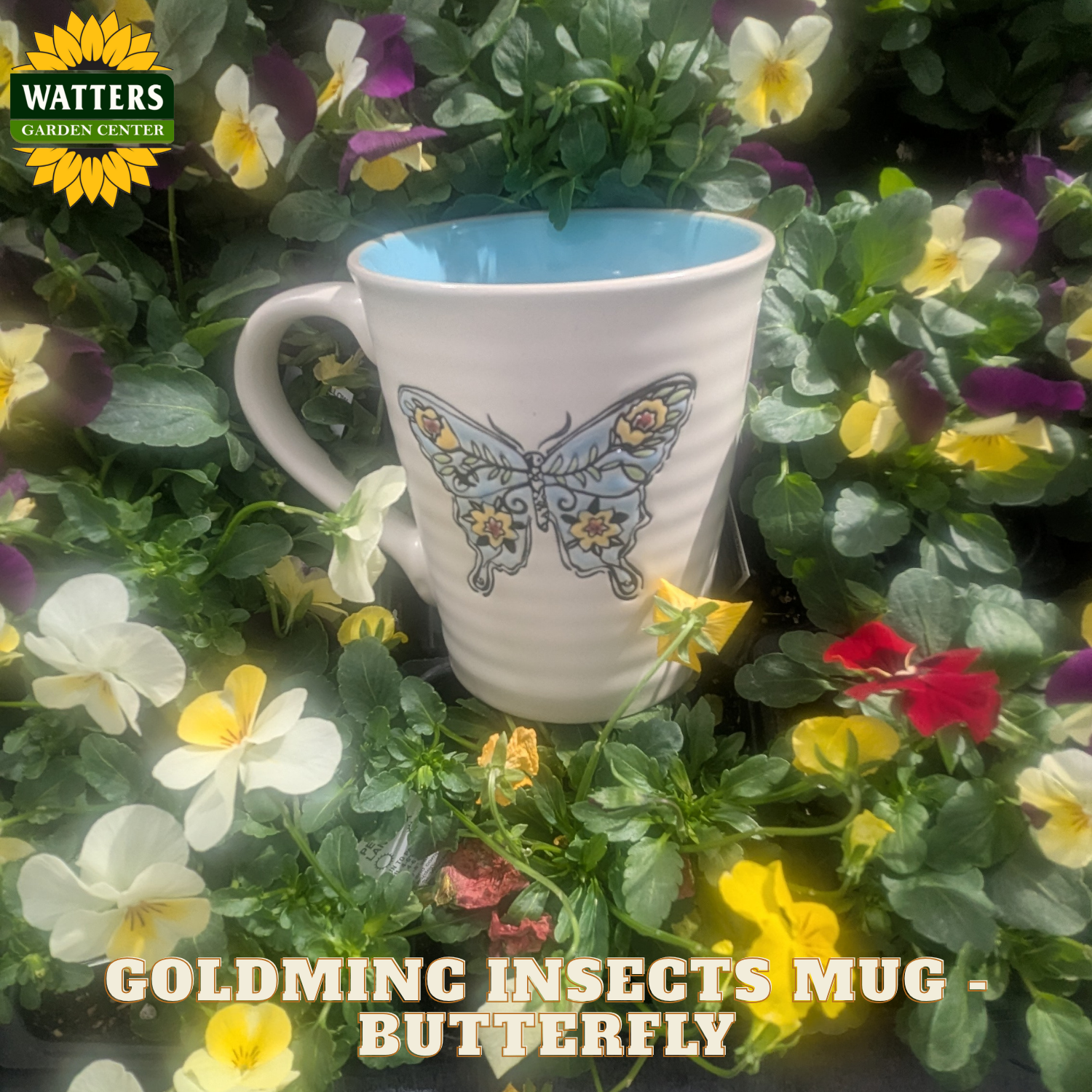 White mug with butterfly design on a bed of flowers, featuring Watters Garden Center branding.
