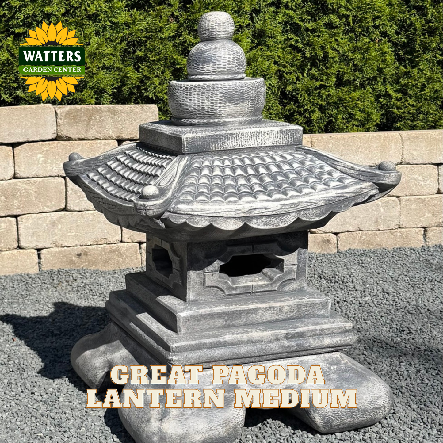 A gray stone-style pagoda lantern garden statue shown outdoors on gravel in front of a stone wall and green hedge. The Watters Garden Center logo appears in the top left, and the text 'GREAT PAGODA LANTERN MEDIUM' is overlaid at the bottom.