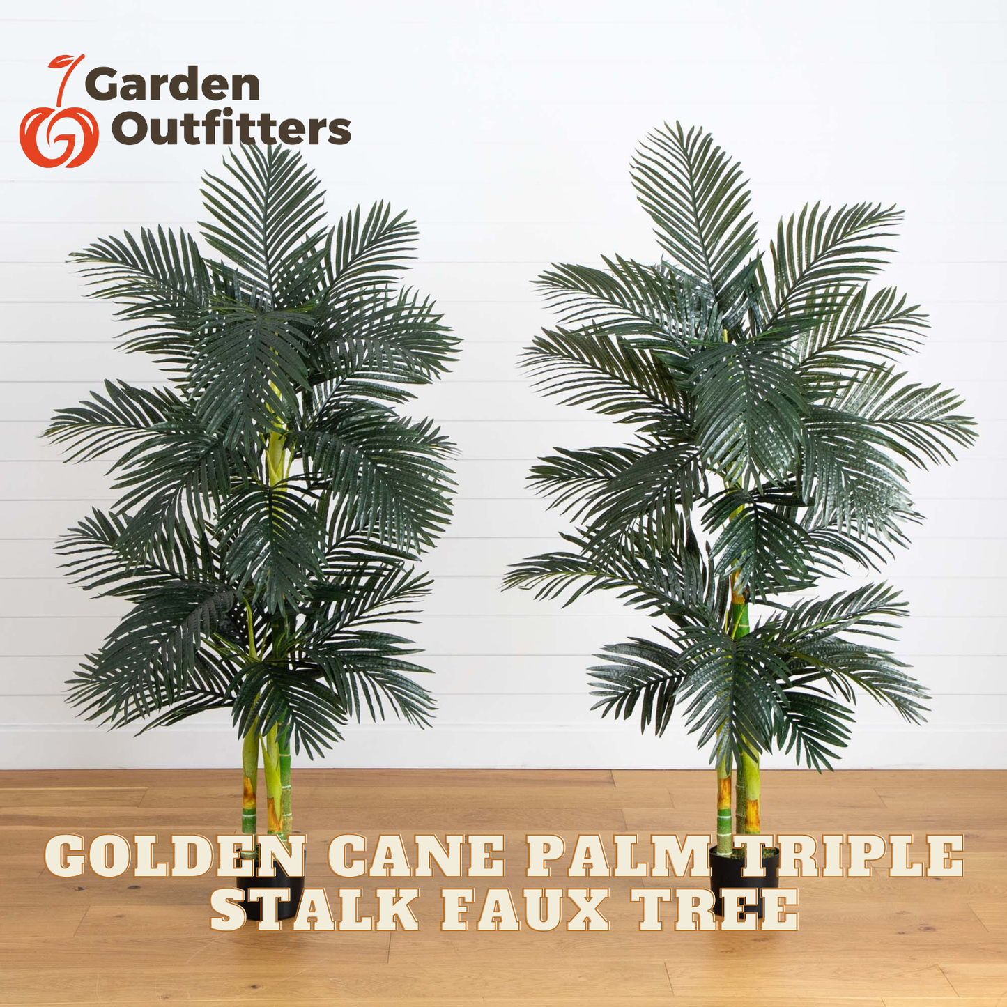 Two artificial golden cane palm trees displayed side by side against a white paneled wall on a light wood floor, with the Garden Outfitters logo in the top left and text reading 'GOLDEN CANE PALM TRIPLE STALK FAUX TREE' at the bottom.