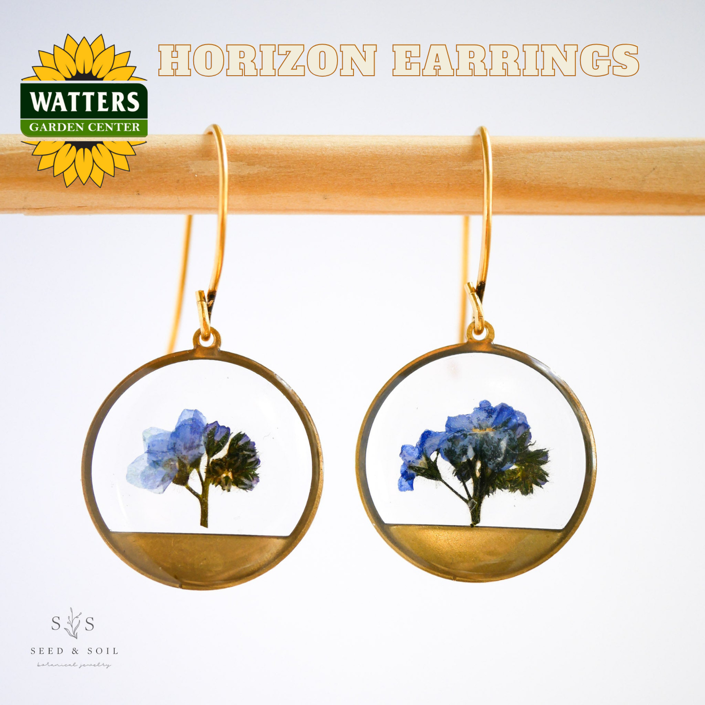 Gold hoop earrings with floral design on a white background, featuring Watters Garden Center logo.