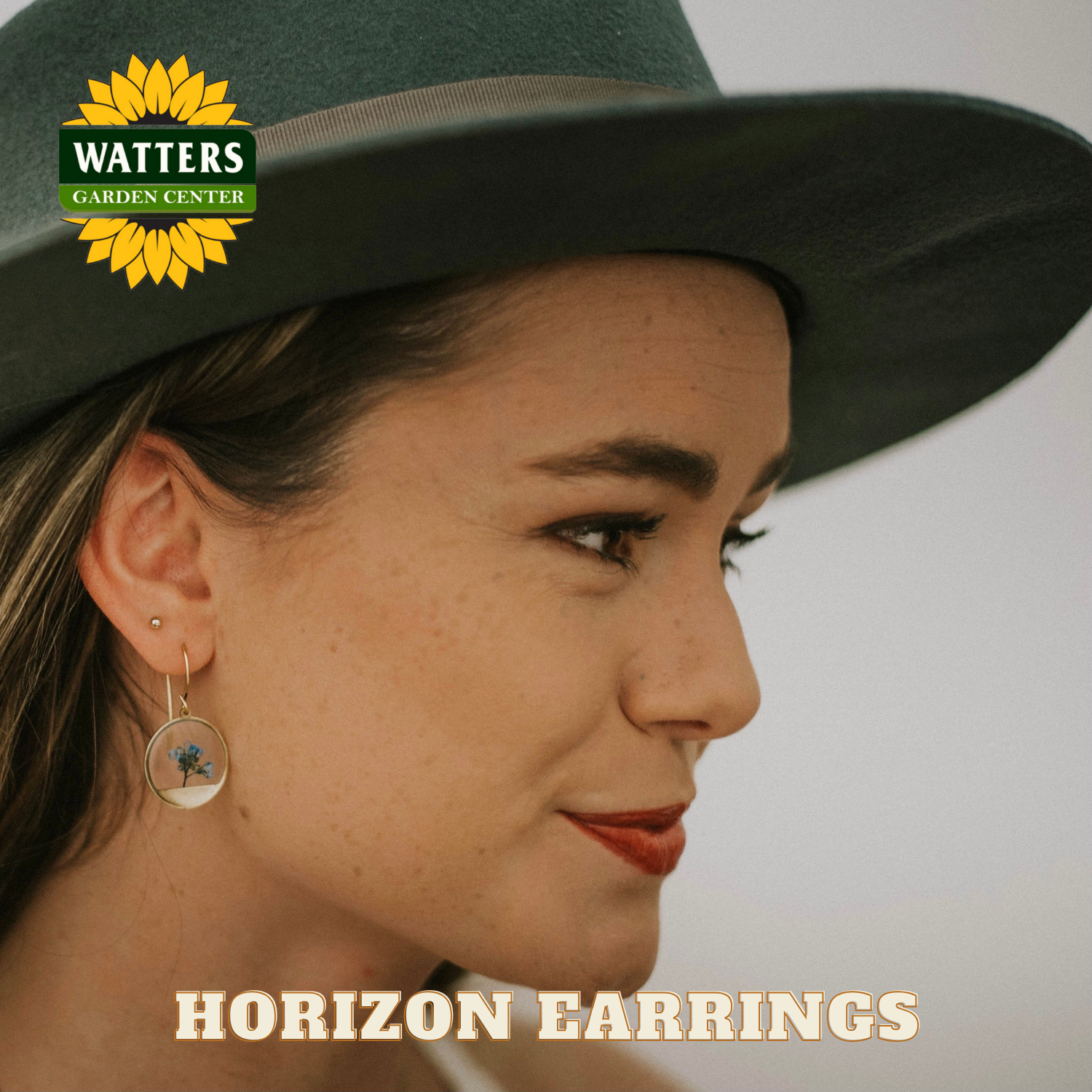 Woman wearing a green hat with 'Watters Garden Center' logo and 'Horizon Earrings' text.