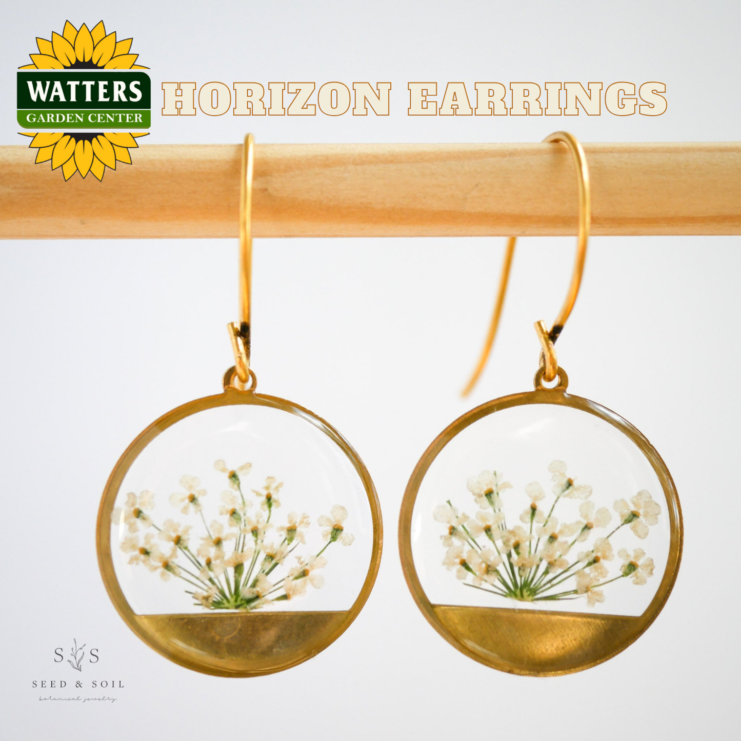 Gold hoop earrings with floral design on a white background, featuring Watters Garden Center logo.