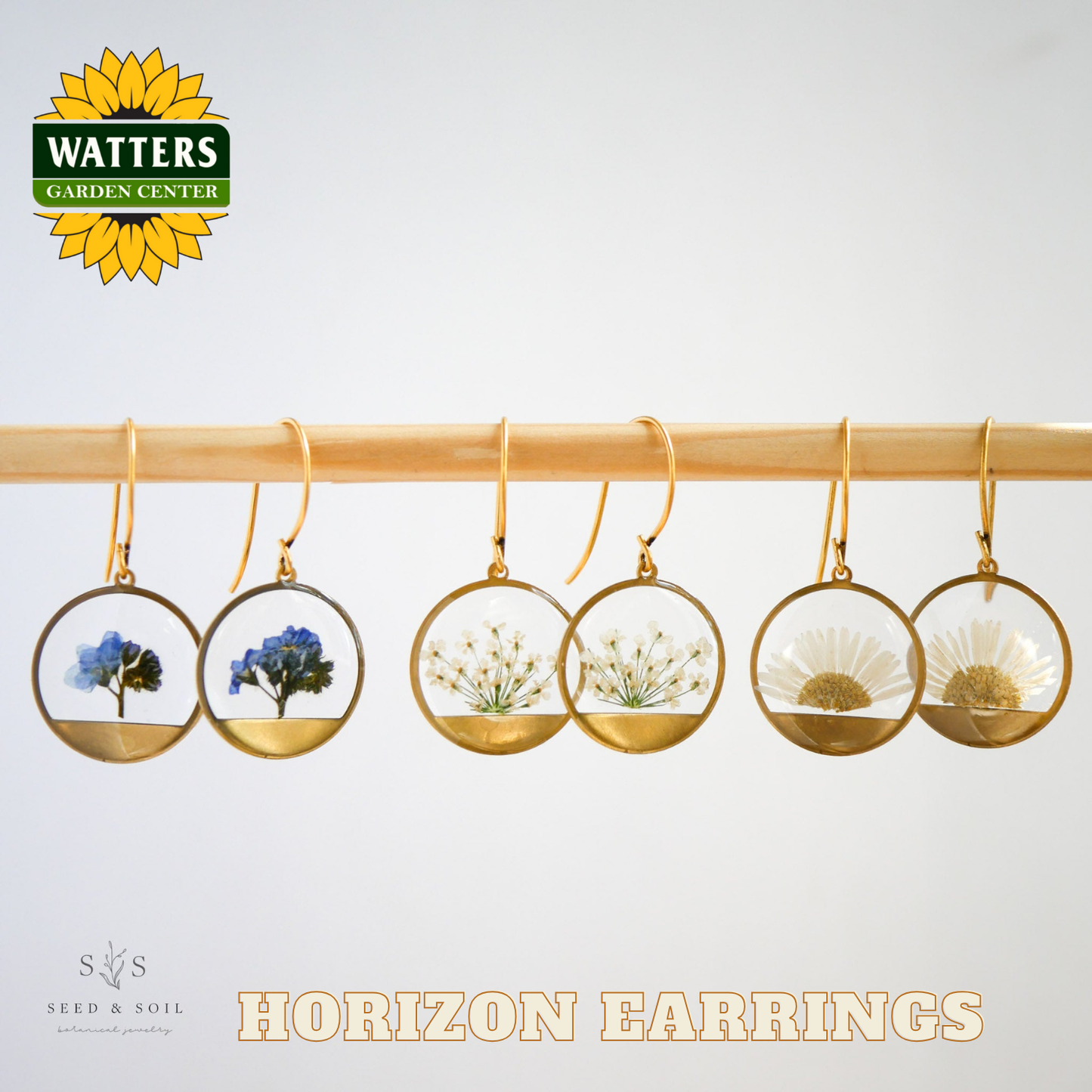 Gold hoop earrings with natural elements on a white background, featuring Watters Garden Center logo.
