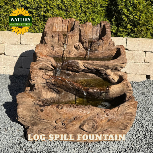 Wooden log spill fountain with Watters Garden Center branding in the background.