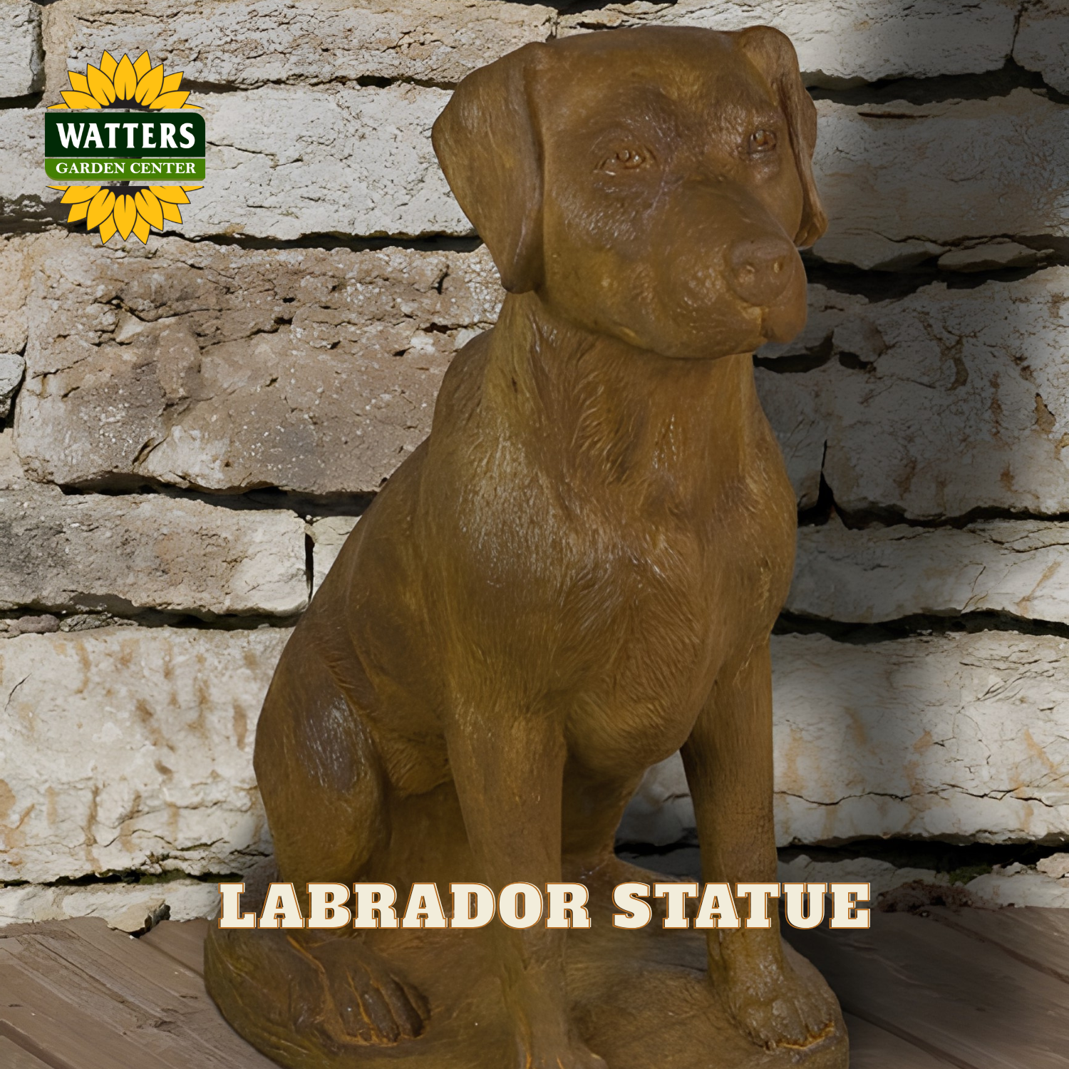 A brown resin statue of a sitting Labrador retriever, displayed against a rustic white brick wall background. The Watters Gardens Center logo is visible in the top-left corner, and the text 'LABRADOR STATUE' is overlaid at the bottom.