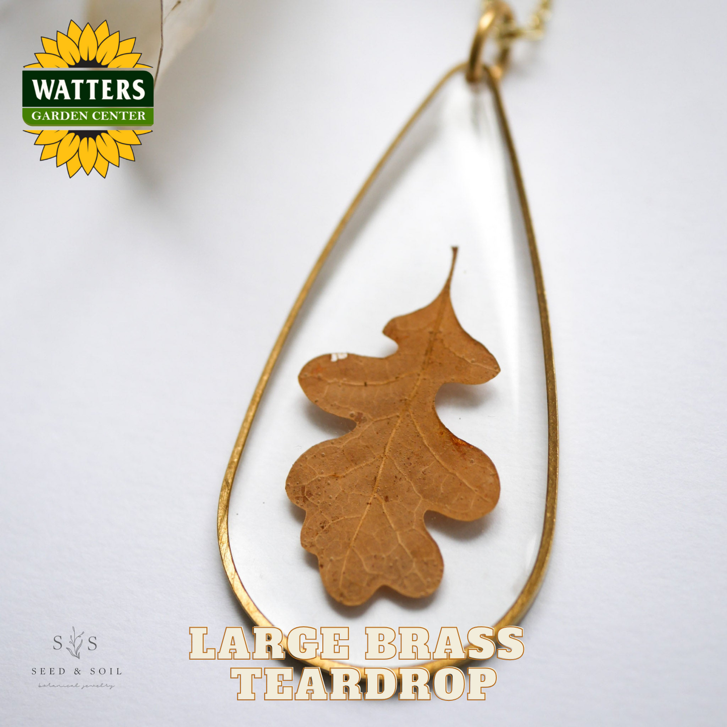 Large brass teardrop-shaped pendant with a leaf design on a white background, featuring Watters Garden Center logo.