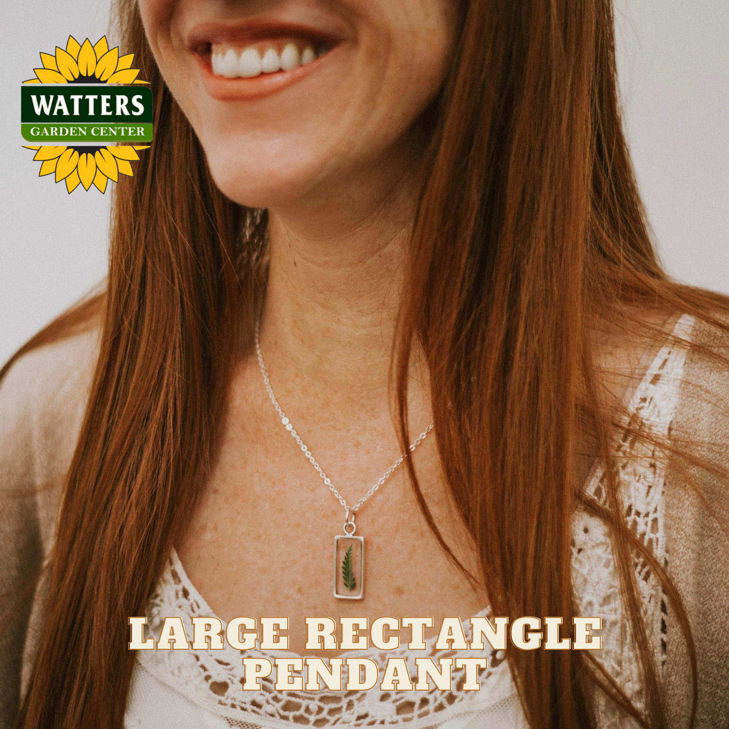 Woman wearing a necklace with a large rectangle pendant, Watters Garden Center logo visible.