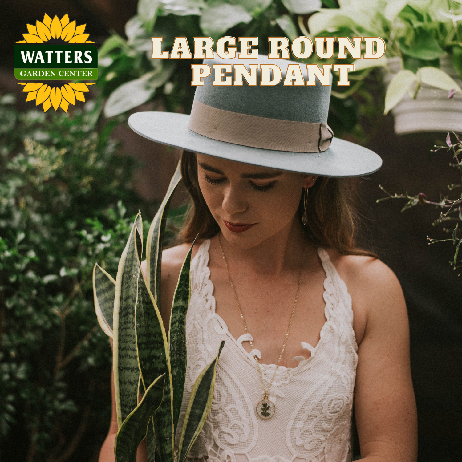 Woman wearing a large round pendant hat with Watters Garden Center branding.