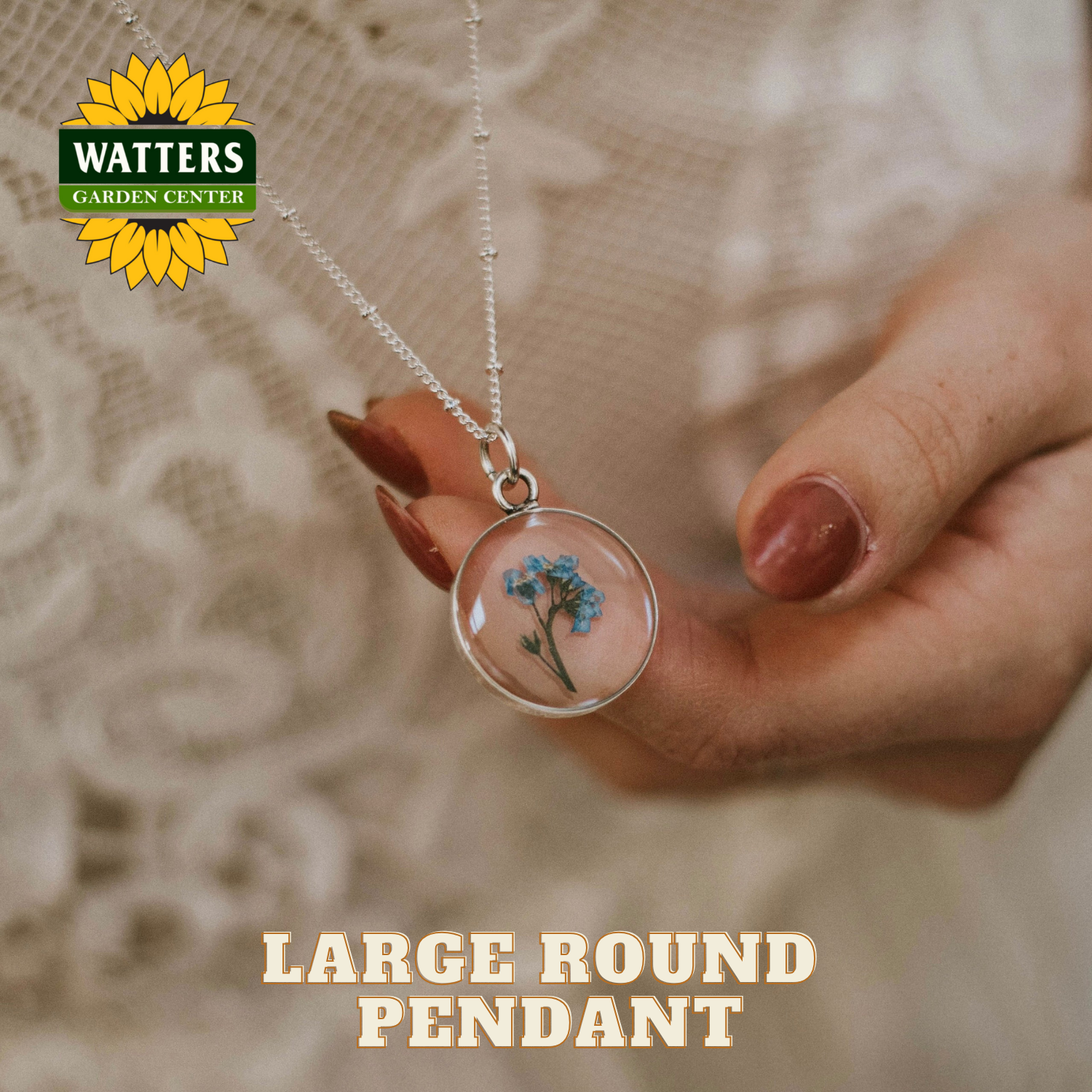 Hand holding a large round pendant with flowers, Watters Garden Center logo visible.