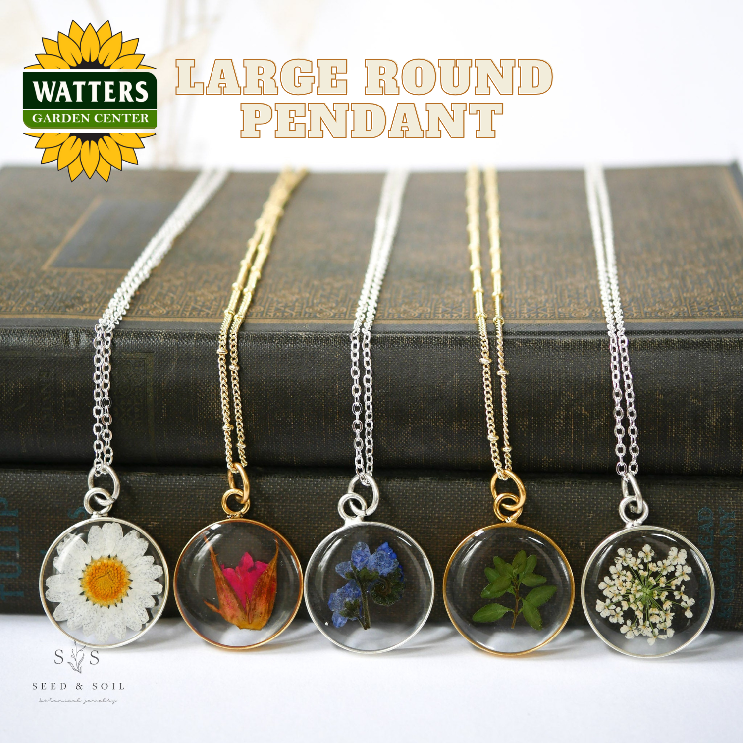 Five necklaces with round pendants featuring pressed flowers on a book, with Watters Garden Center branding.