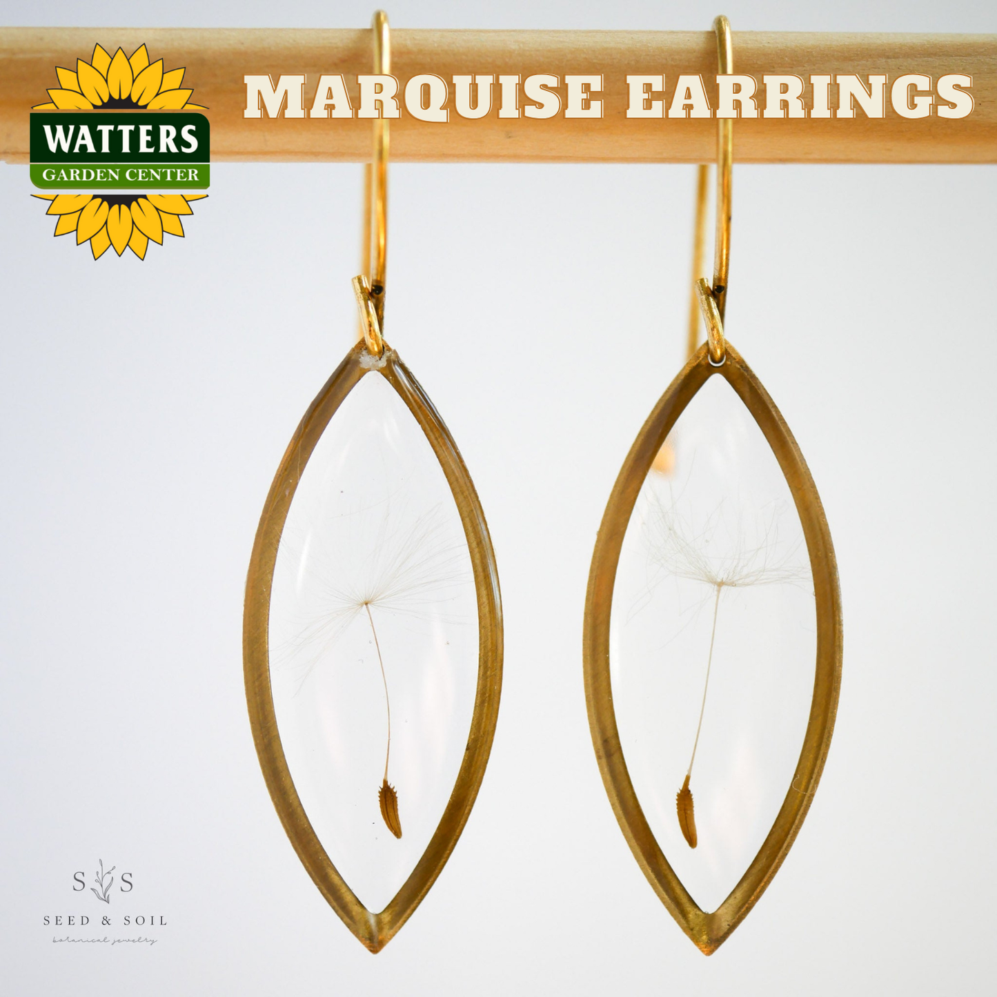 Gold marquise earrings hanging on a wooden rod with 'Watters Garden Center' logo.