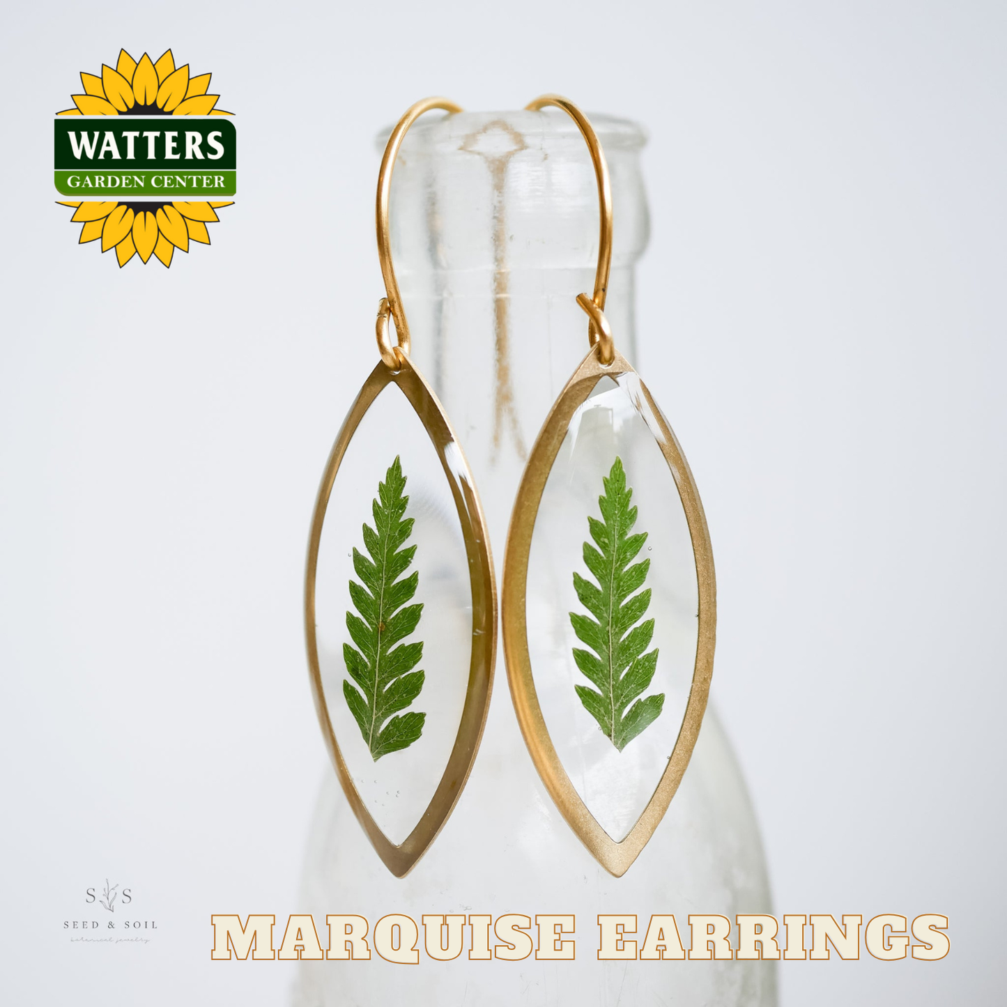 Marquise earrings with green leaf design on a white background, featuring Watters Garden Center logo.