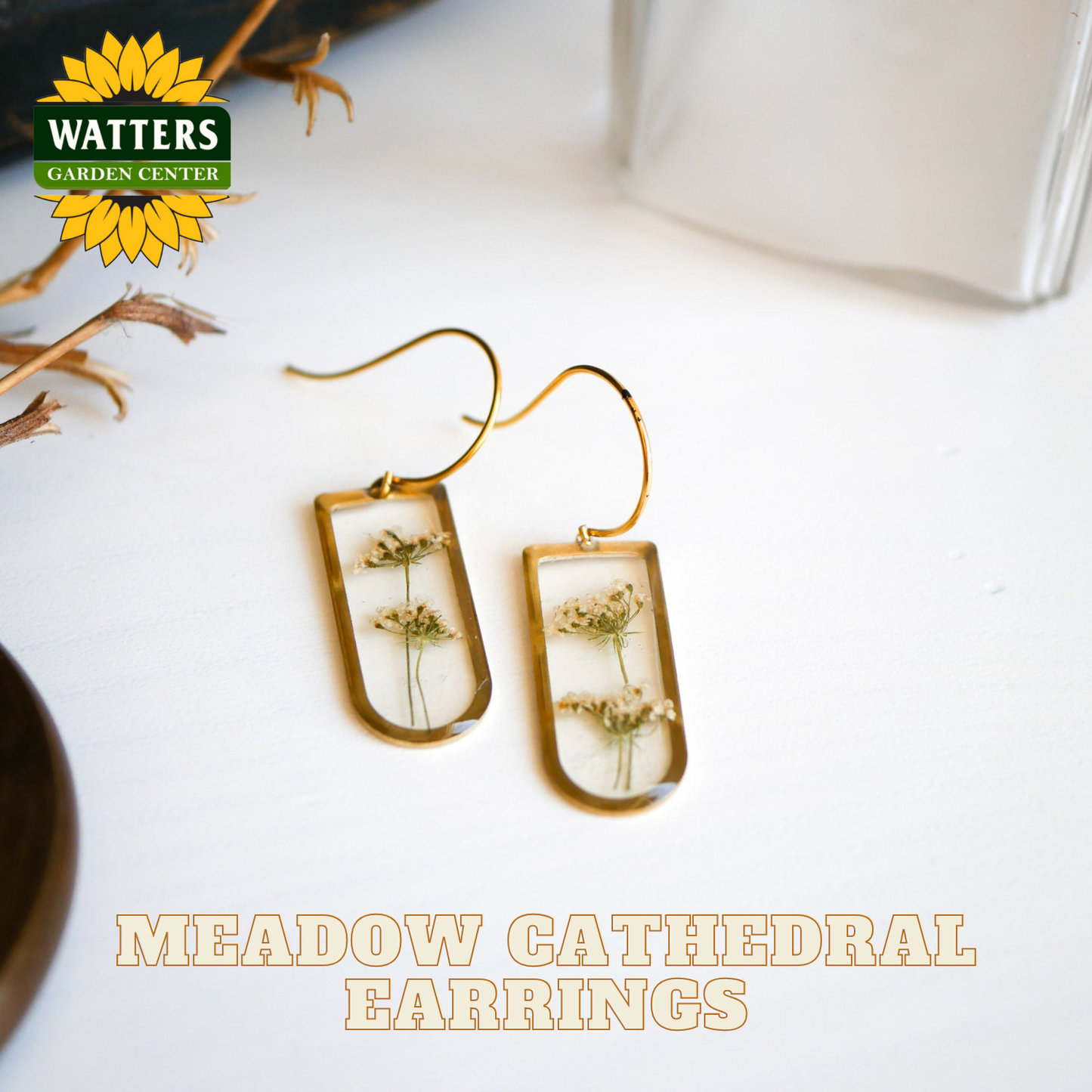 Meadow Cathedral earrings with dried flowers on a white surface, branded with Watters Garden Center.
