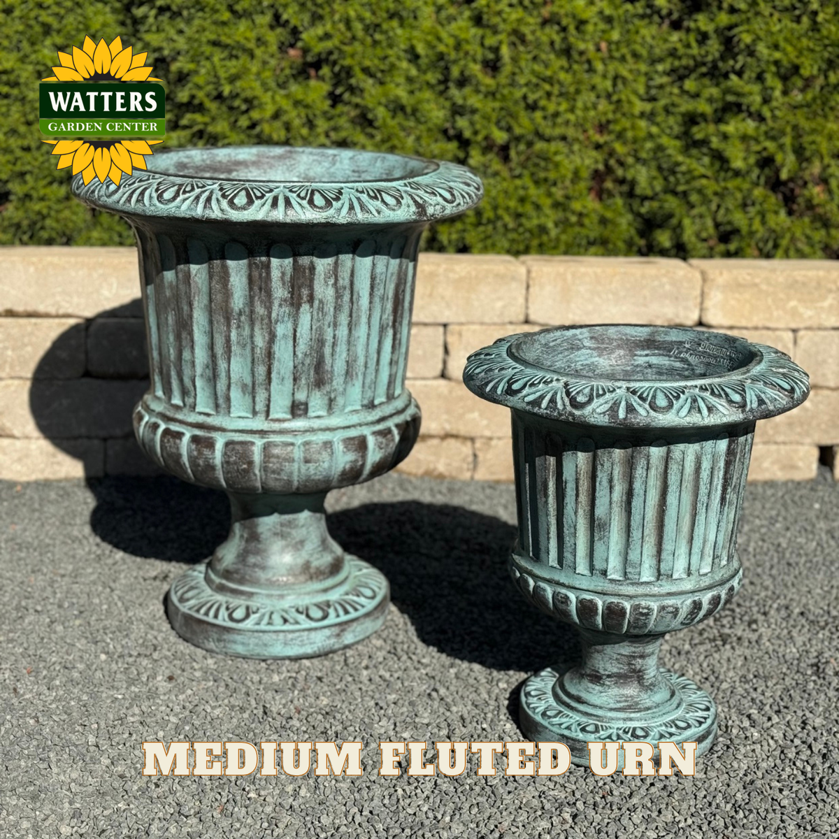Fluted urn in a garden setting with Watters Branding.