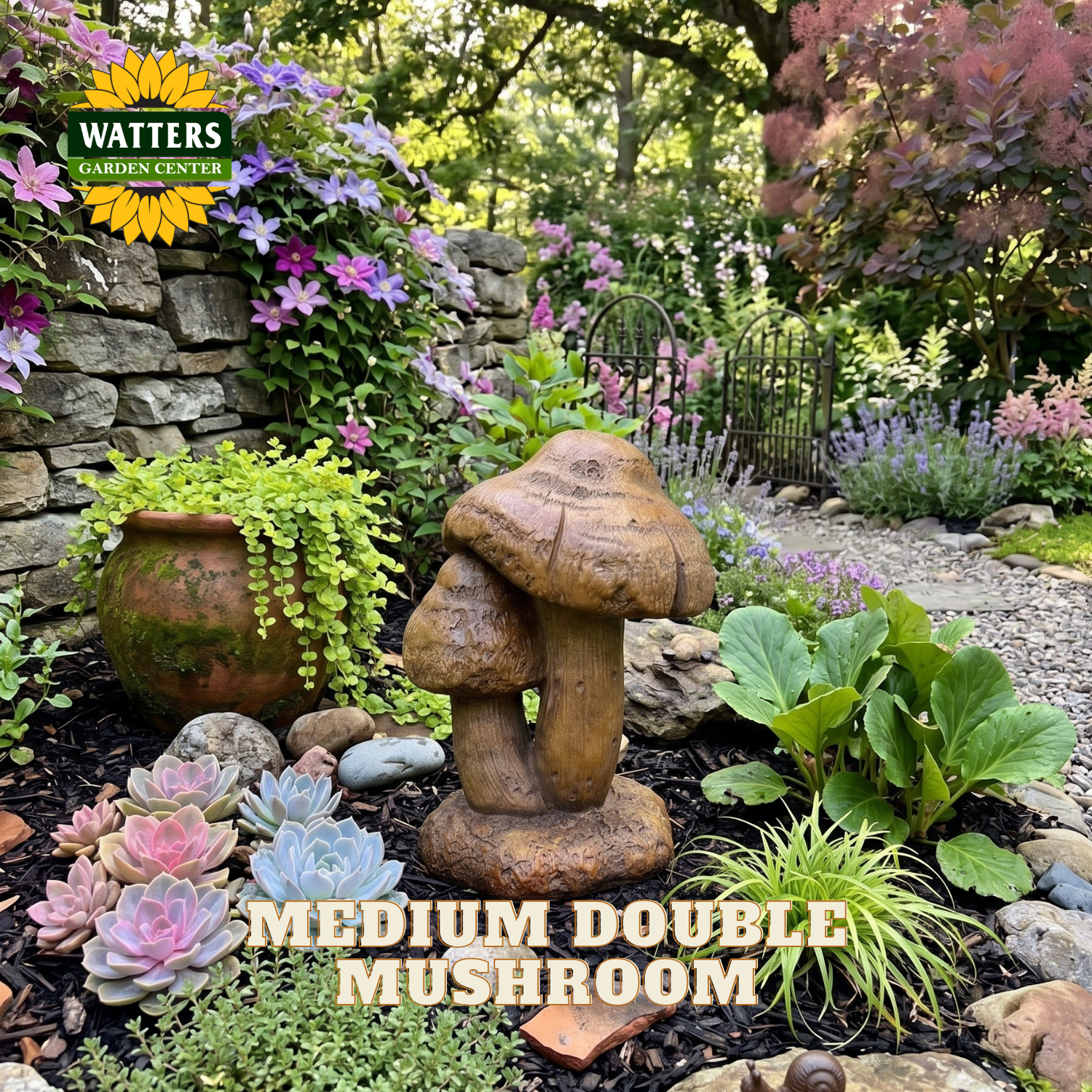 A garden stone decorative figure shaped like two stacked mushrooms, placed in a landscaped garden bed with succulents, flowers, a stone wall, and a gravel path. Text overlay reads 'MEDIUM DOUBLE MUSHROOM' and a Watters Gardens Center logo appears in the top left.