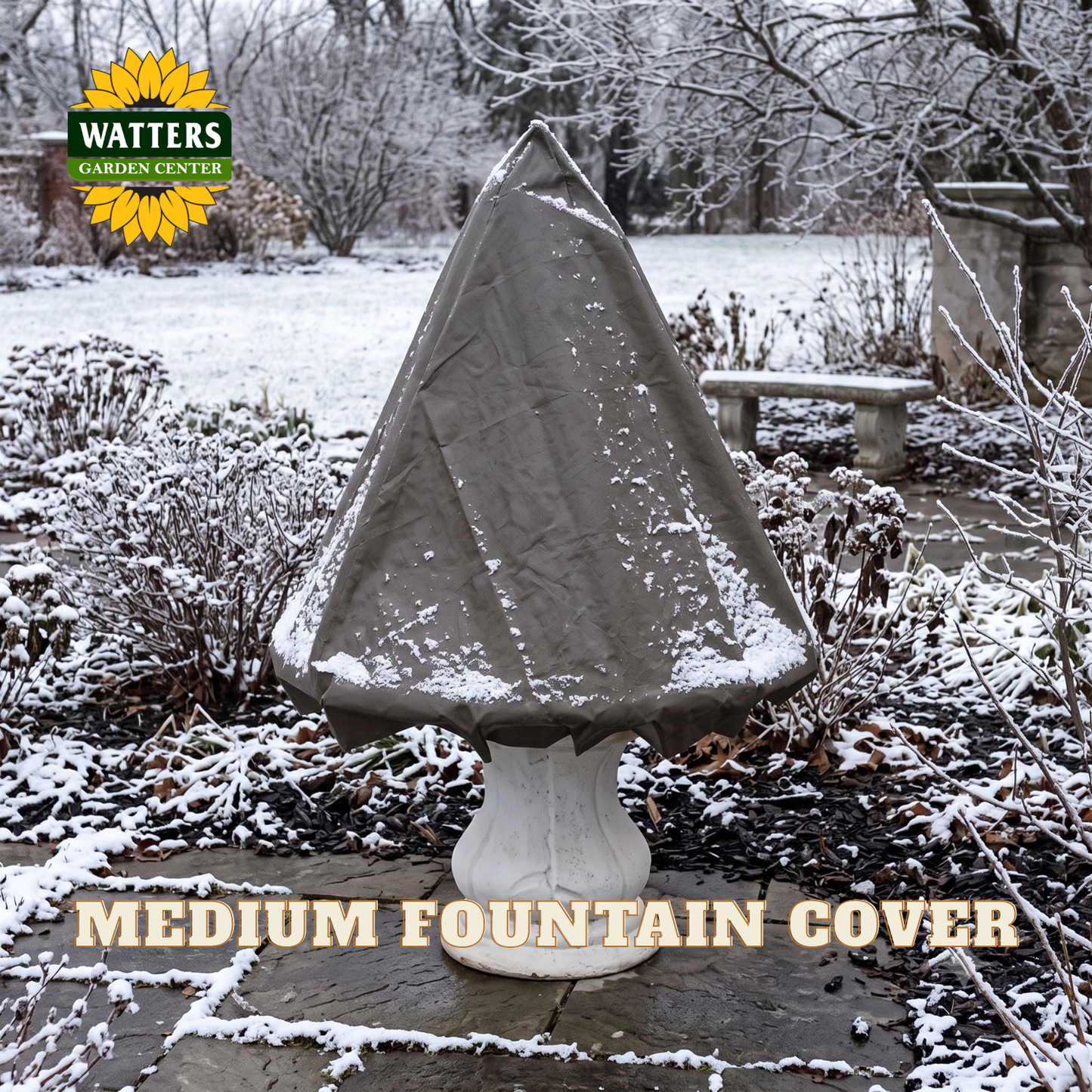 A gray fabric fountain cover draped over a white pedestal fountain in a snowy outdoor garden setting. The Watters Gardens Center logo appears in the top left, and the text 'MEDIUM FOUNTAIN COVER' is displayed at the bottom.