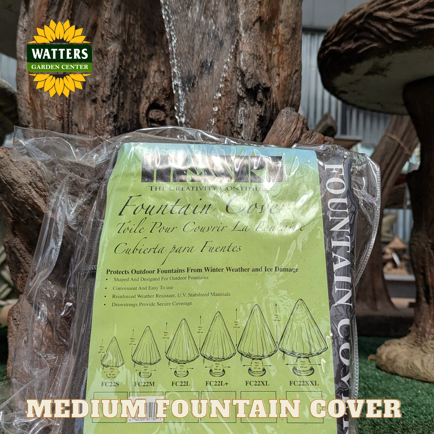 A packaged Watters Gardens Center fountain cover for a medium-sized pond, shown wrapped in clear plastic with the product instructions and size diagrams visible on the front label.