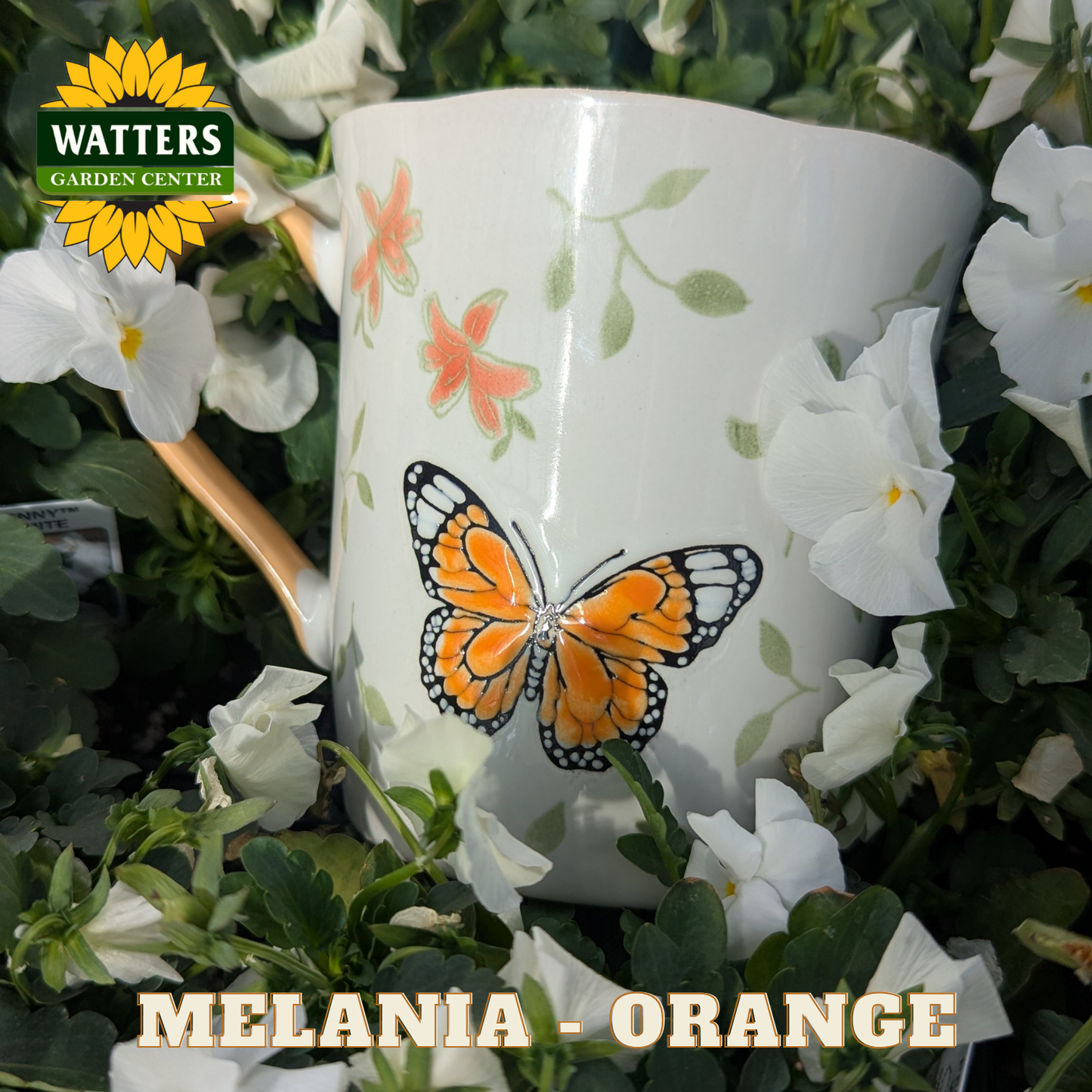 White mug with butterfly design surrounded by white flowers and greenery, with Watters Garden Center logo.
