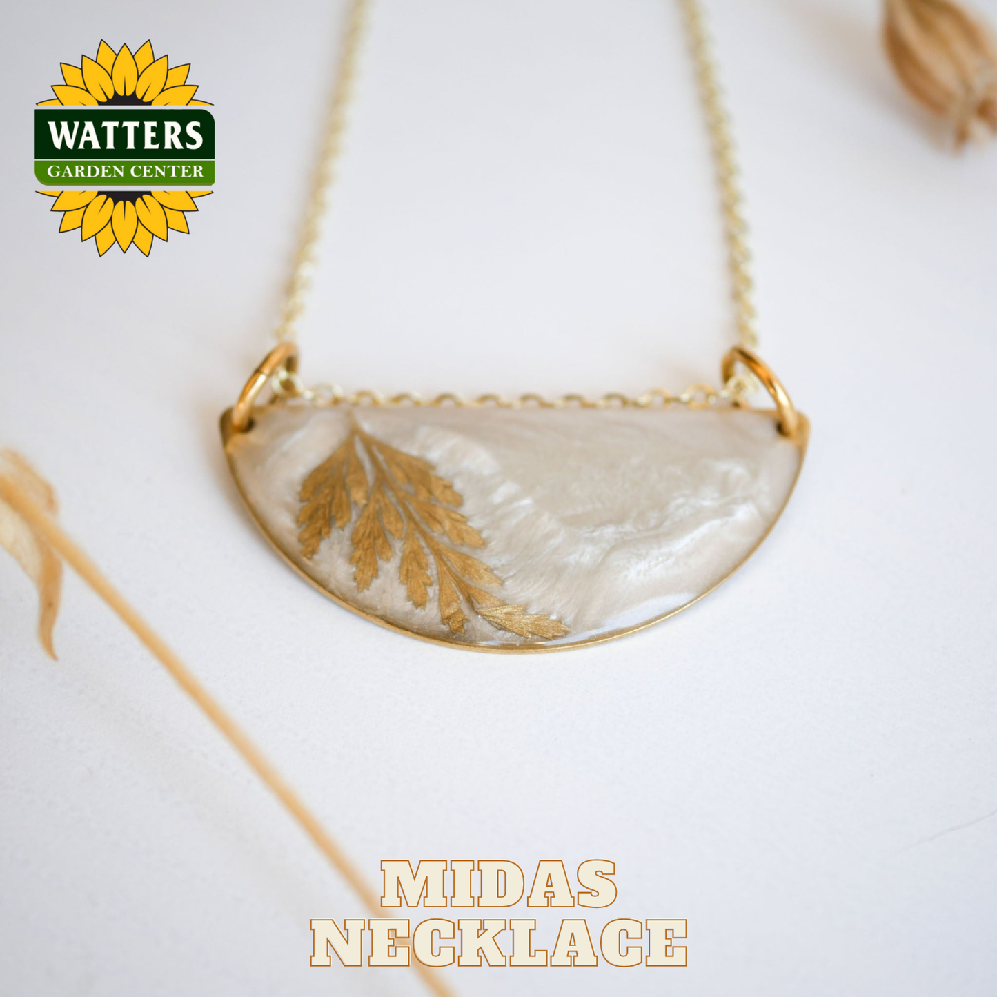 Necklace with a gold leaf design on a white background, featuring Watters Garden Center logo.