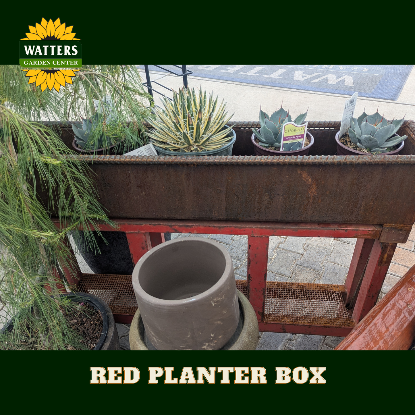 Red and bronze planter box in a garden setting.