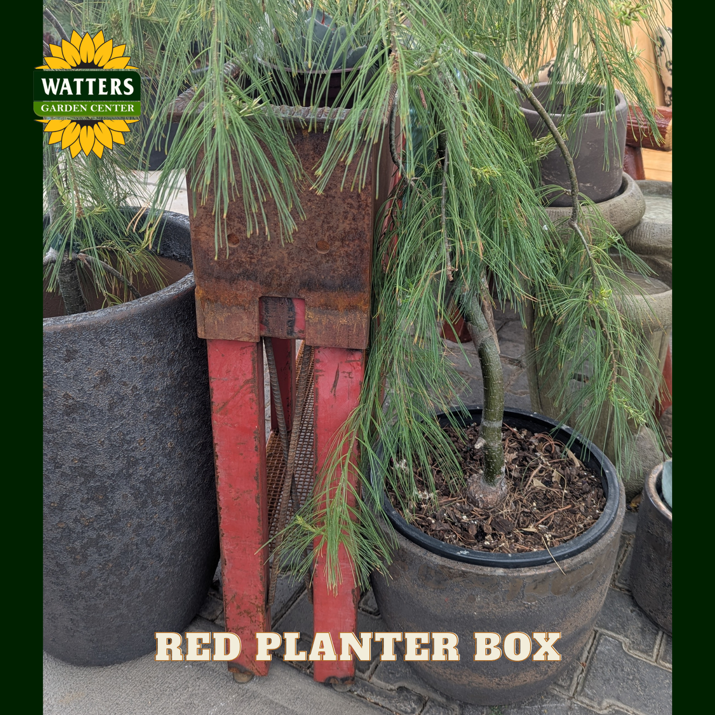 Red and bronze planter box in a garden setting.