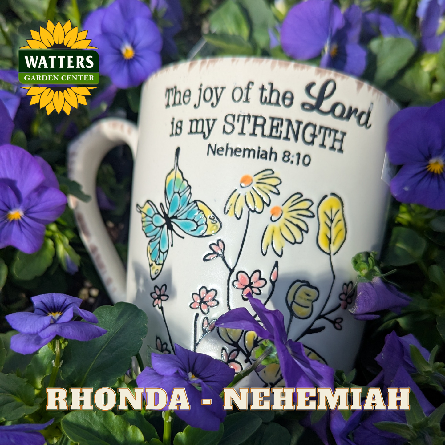 Mug with floral design and Bible verse text surrounded by purple flowers, featuring Watters Garden Center logo.
