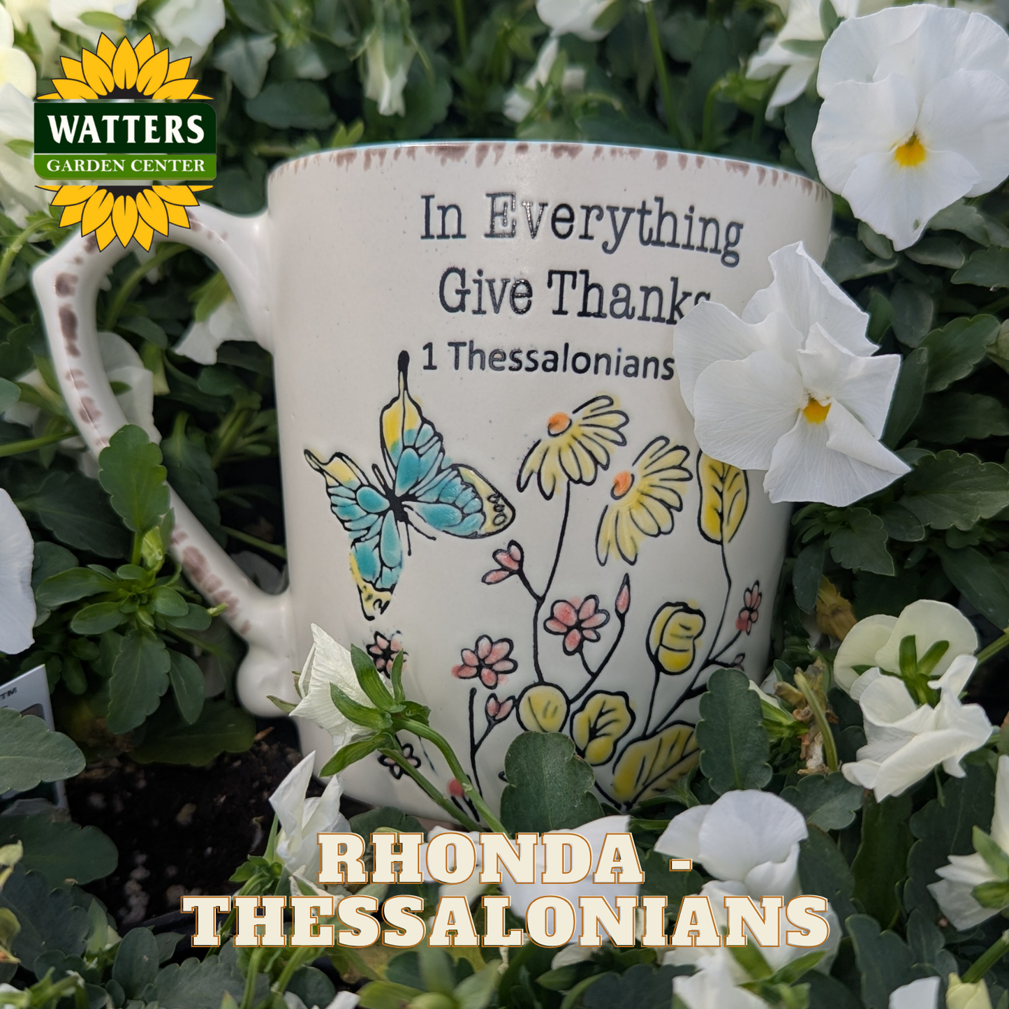 Decorative mug with floral design and motivational quote in a garden setting, featuring Watters Garden Center branding.