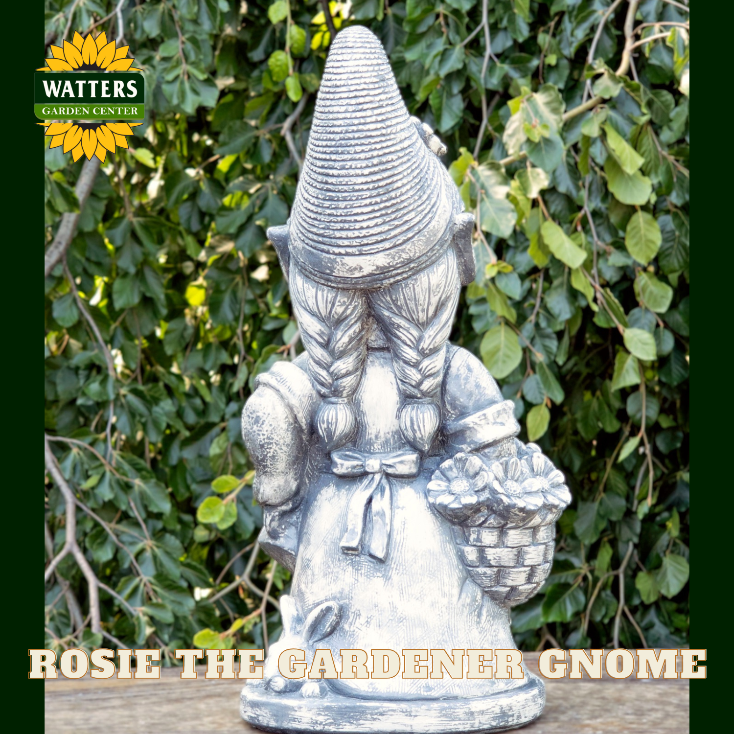 Back of the lady garden gnome holding garden tools and a basket of flowers in a garden setting. Watters logo branding on the image.