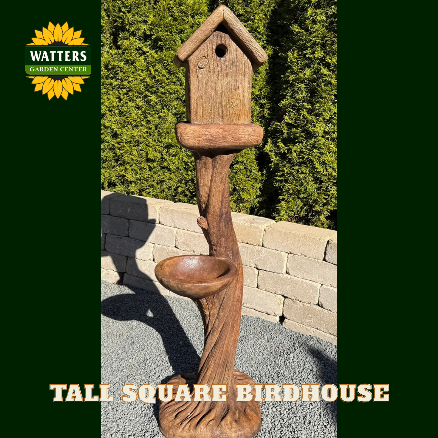 Wooden birdhouse with attached bird bath on a stone patio, branded with Watters Garden Center.