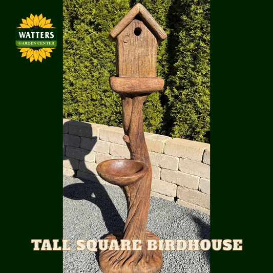 Wooden birdhouse with attached bird bath on a stone patio, branded with Watters Garden Center.
