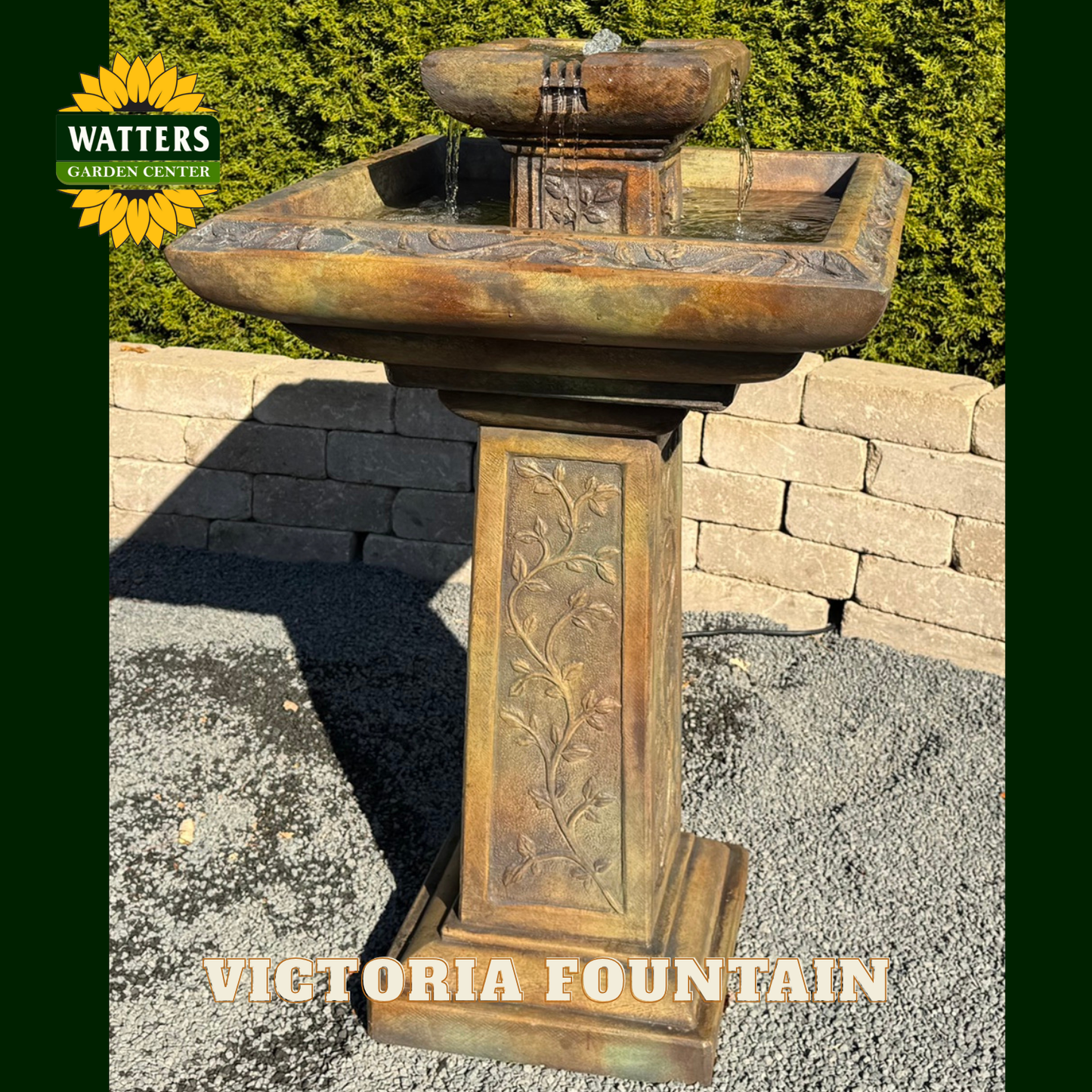 Decorative outdoor fountain with 'Watters Garden Center' branding in a garden setting.
