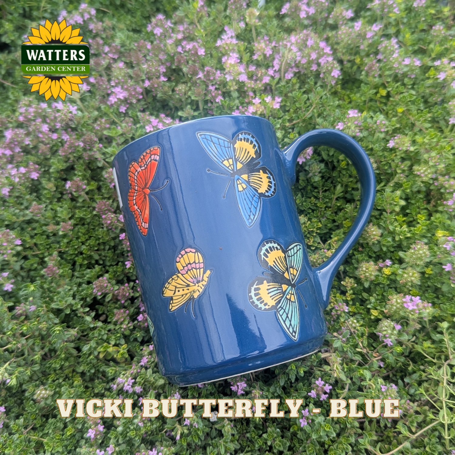 Blue mug with butterfly designs on a green background