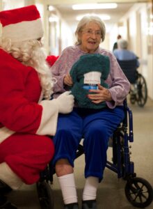 santa kneeling with a senior citizen in a wheelchair