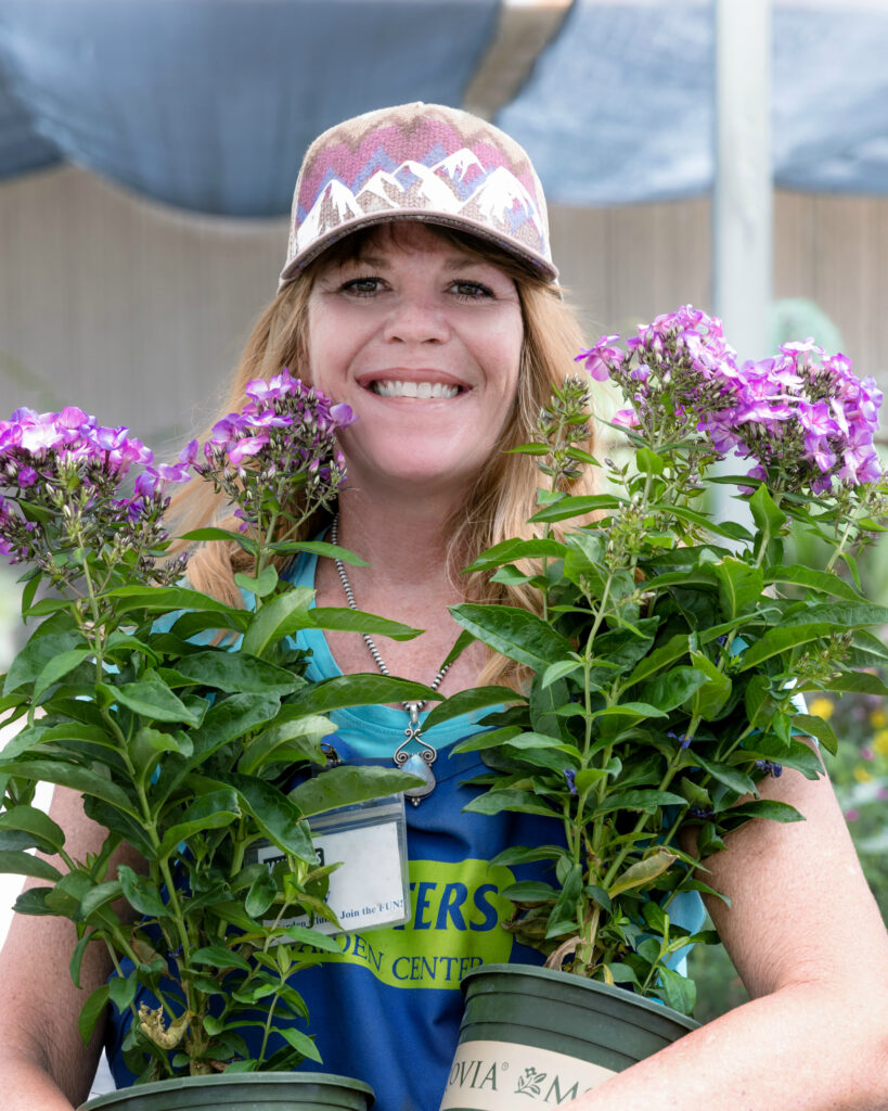 Amy Langley AZ Certified Nursery Professional holding plants at the garden center