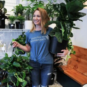 Young Woman holding a large houseplant